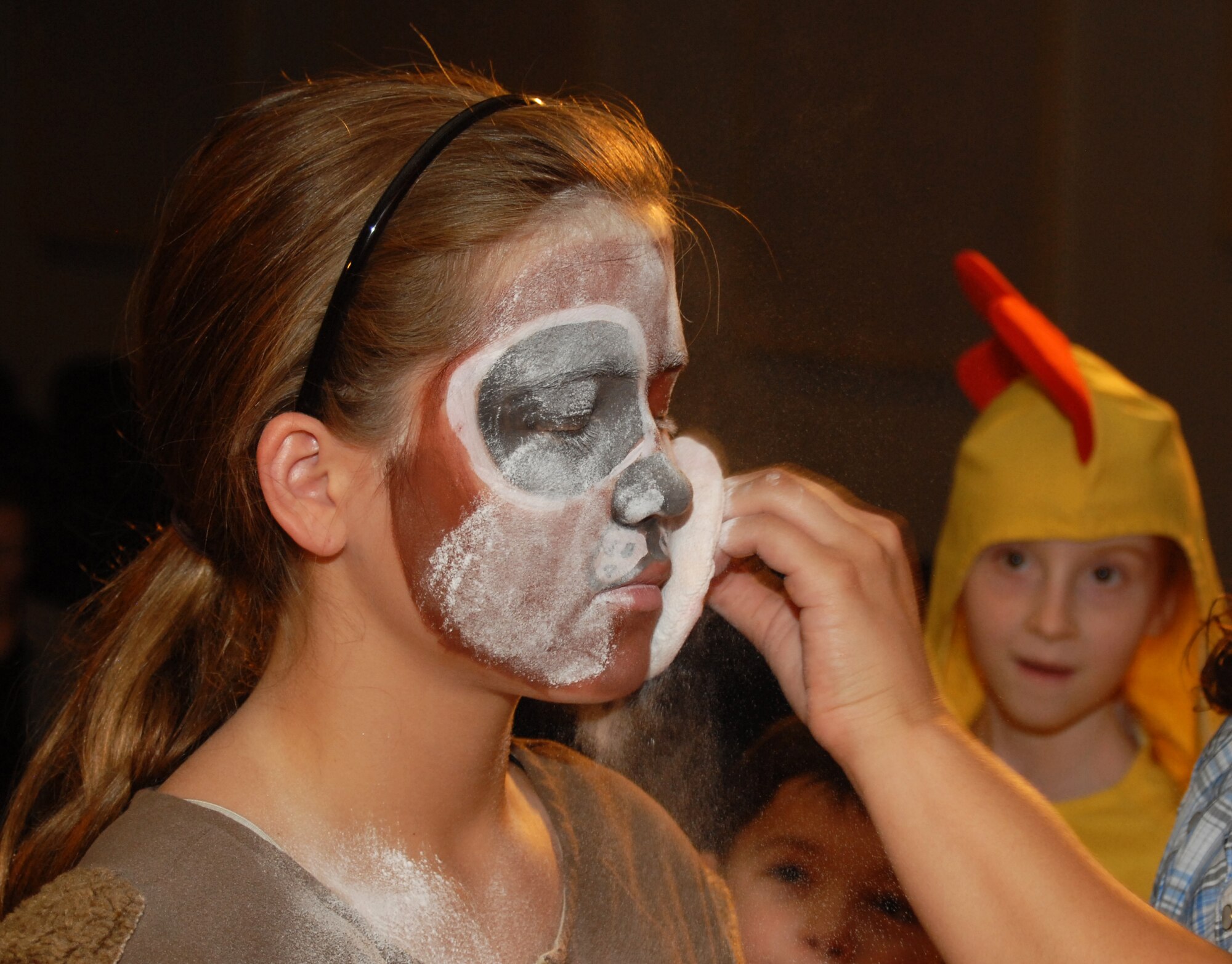Emily Lescarbeau gets some powder over her make-up before the night's performance, while Kathrine Ingalls and Harrison Snarr look on at the Goodfellow AFB base theater Aug. 14.  The Missoula Children's Theatre provides a week-long performance workshop and rehearsals that culminate in two full-scale musical public performances starring Goodfellow youth. (U.S. Air Force / Robert D. Martinez)
