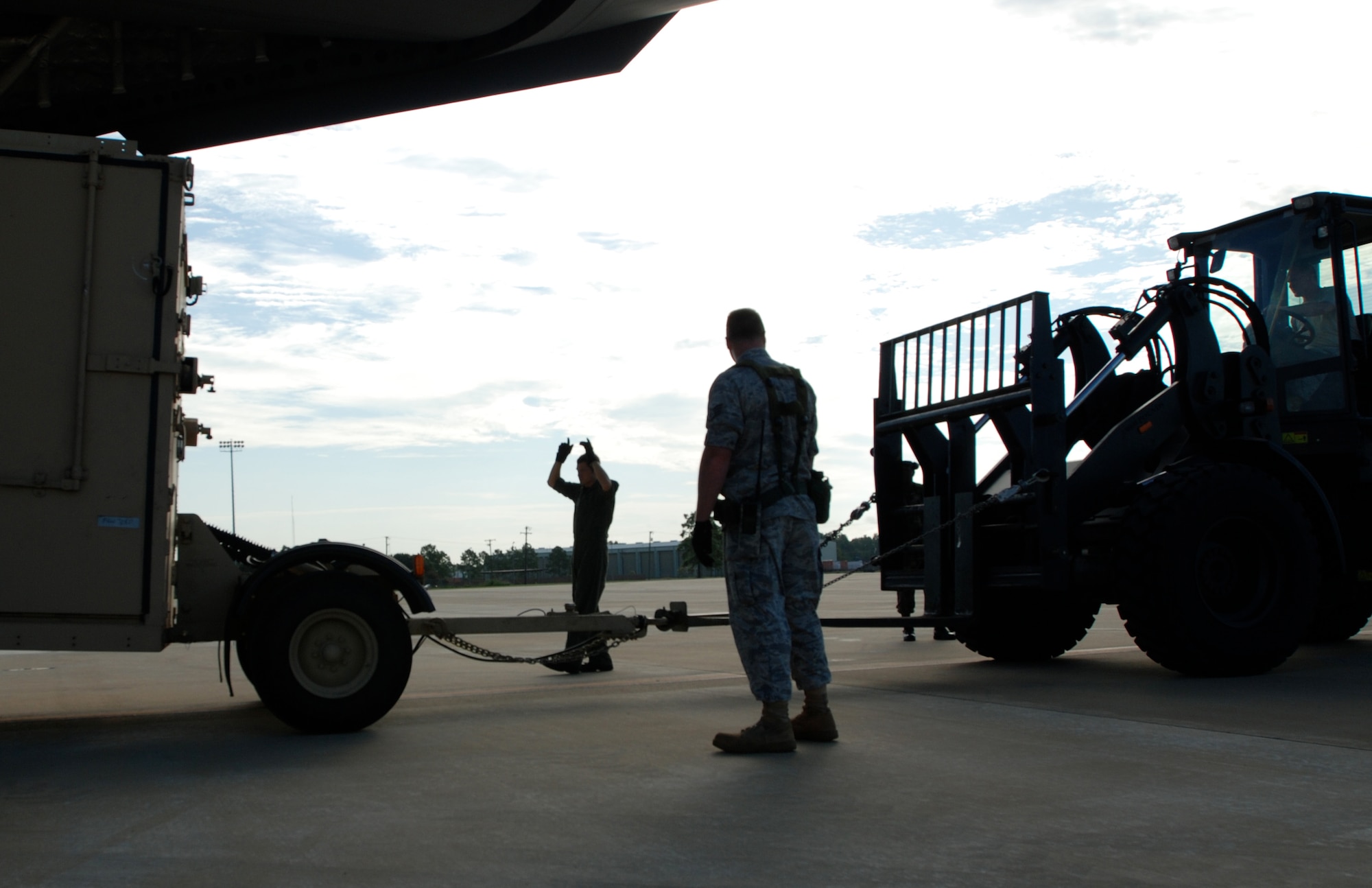 Staff Sgt. Jason Jones, a C-17 Globemaster III loadmaster, helps guide a forklift carrying supplies to a C-17 during the Joint Readiness Training Center Exercise 09-09 on Aug. 18, 2009 at Fort Polk, La.  The JRTC provides realistic training using war-time scenarios that allow integration between joint military organizations, host nations and civilian role-players. Units from the Air Force, Army and Canadian and Belgian air forces are training together during the 09-09 exercise. (U.S. Air Force Photo/Bekah Clark)