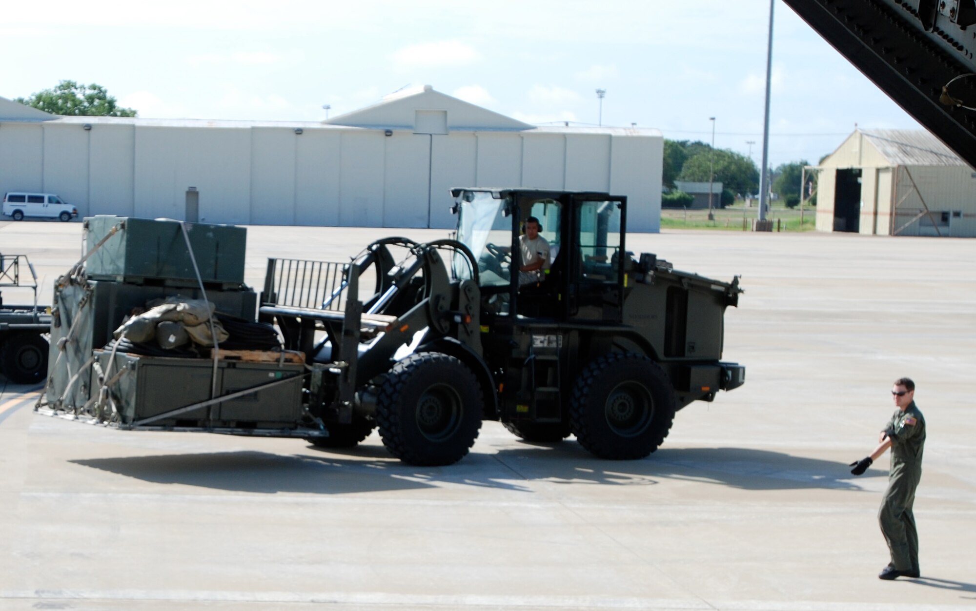 Staff Sgt. Jason Jones, a C-17 Globemaster III loadmaster, helps guide a forklift carrying supplies to a C-17 during the Joint Readiness Training Center Exercise 09-09 on Aug. 18, 2009, at Fort Polk, La.  The JRTC provides realistic training using war-time scenarios that allow integration between joint military organizations, host nations and civilian role-players. Units from the U.S. Air Force, Army and from the Canadian and Belgian air forces are training together during the 09-09 exercise. (U.S. Air Force Photo/Bekah Clark)