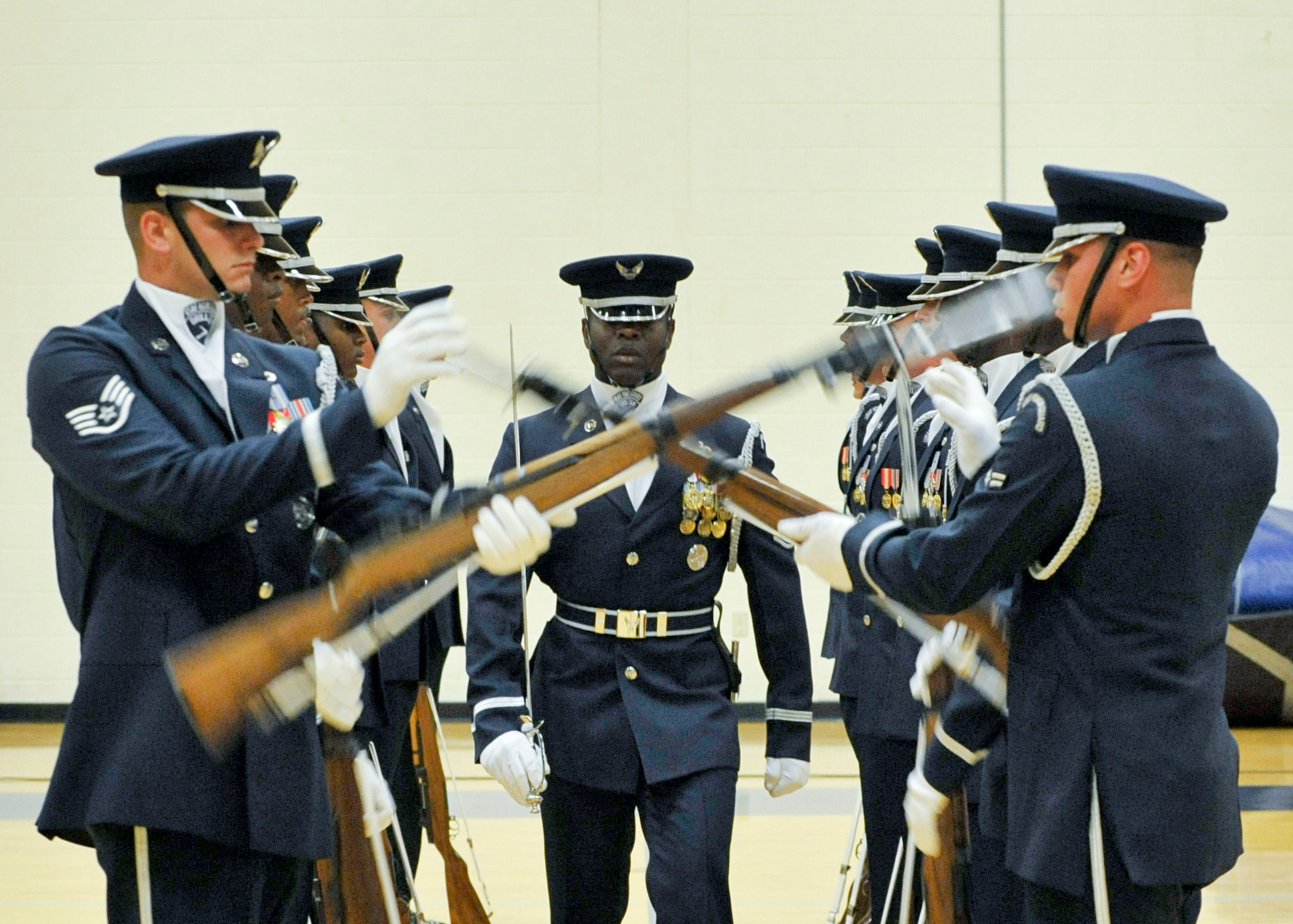 The United States Air Force Honor Guard performs for Team Tyndall in the gymnasium Aug. 20.  This standard 16-person performance features a professionally choreographed sequence of show-stopping weapon maneuvers, precise tosses, complex weapon exchanges, and a walk through the gauntlet of spinning weapons.  (U.S. Air Force photo/Jonathon Gibson)