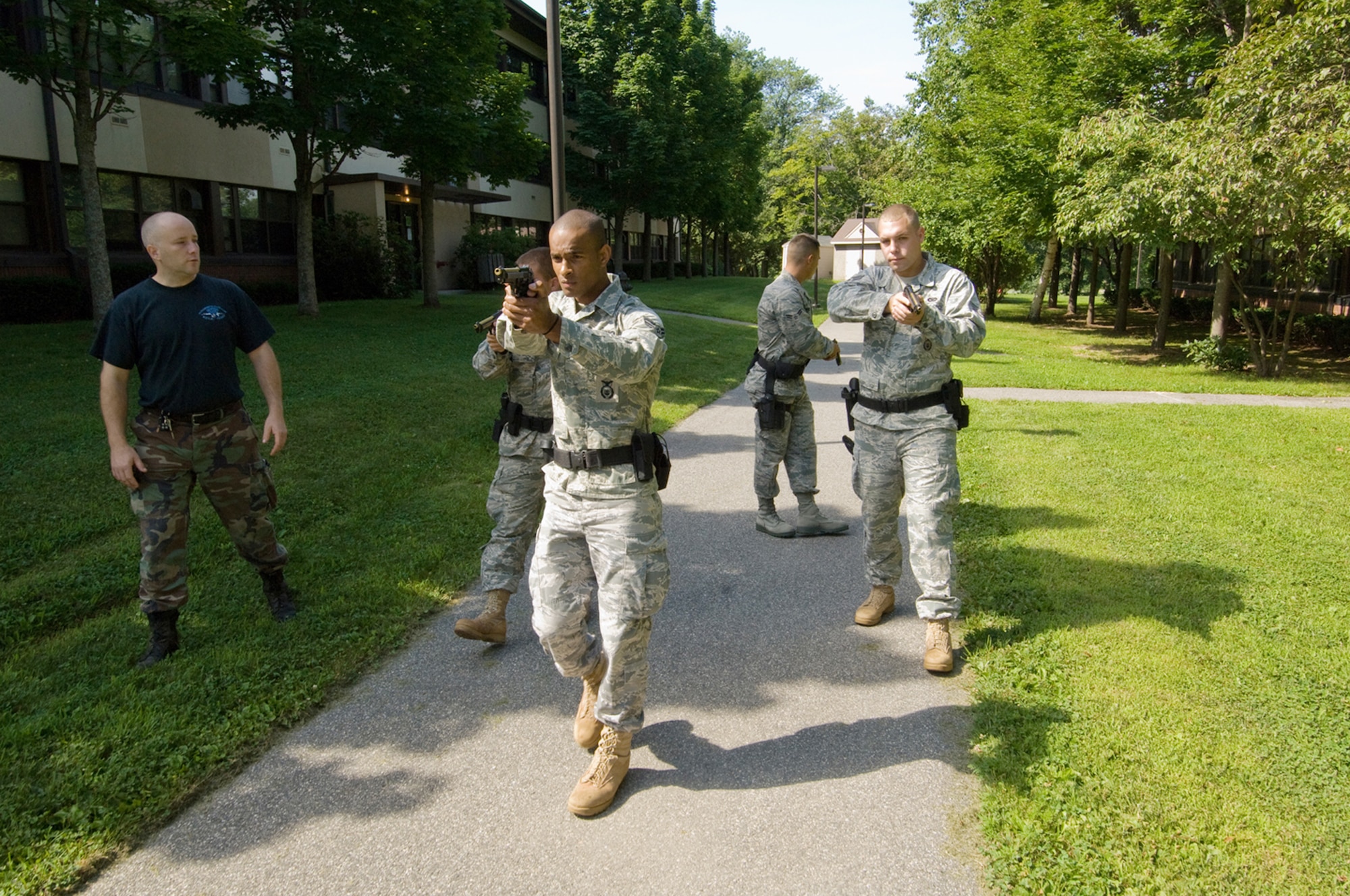 A Massachusetts State Police Special Tactical Operations Team monitors as Senior Airman Mark Cayer, Airman 1st Class Ronald Ashley, Airman 1st Class Edwin Torres and Senior Airman John Reed to learn methods for neutralizing an active shooter Aug. 6 at Hanscom Air Force Base, Mass. Massachusetts State Police Special Tactical Operations Team members educated Airmen on moving into and within the threat space using a diamond formation, where each member of the four-man team monitors a quarter of the 360-degree view around them. The Airmen are assigned to the 66th Security Forces Squadron. (U.S. Air Force photo/Rick Berry) 