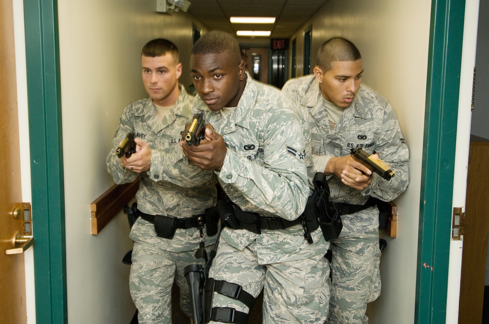 Airman 1st Class Jeffrey Lavey (from left to right), Airman 1st Class Nicholas Taylor and Airman 1st Class Abraham Medina move along the corridors of a base dormitory during a training session with the Massachusetts State Police Special Tactical Operations Team where they learned how to diffuse an active-shooter scenario Aug. 6 at Hanscom Air Force Base, Mass. The Airmen are assigned to the 66th Security Forces Squadron. (U.S. Air Force photo/Rick Berry) 
