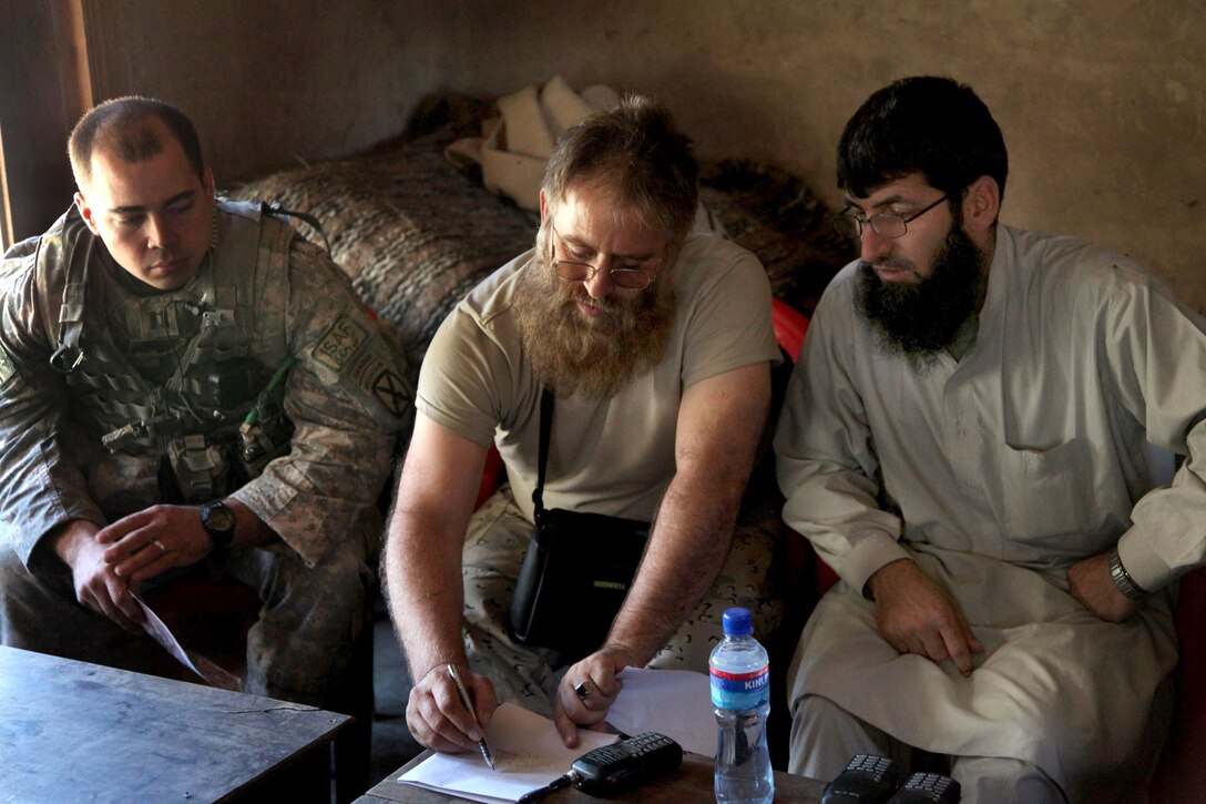 U.S. Army Capt. Justin Sax, left, and Afghan National Police Col. Shams, draw a map to discuss security before the Afghan national elections in Barge Matal in Nuristan province, Afghanistan, Aug. 19, 2009. U.S. troops provided security for the outer Barge Matal area.  Sax is assigned to the 4th Infantry Division's Headquarters Company, 1st Battalion, 32nd Infantry Regiment, 4th Brigade Combat Team.