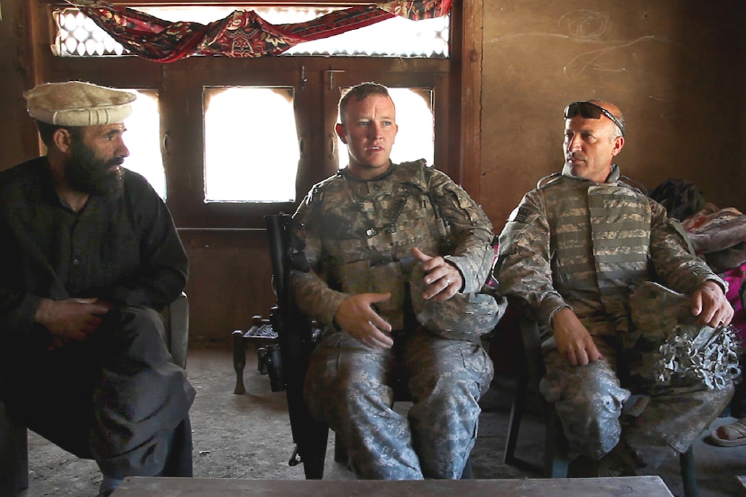 U.S. Army Staff Sgt. Jeremy Parker speaks to a village leader about security in Barge Matal in Nuristan province, Afghanistan, Aug. 19, 2009, before the Afghan national elections. U.S. troops provided security in the area to support the Afghan-run event. Parker is assigned to the 405th Civil Affairs Battalion.