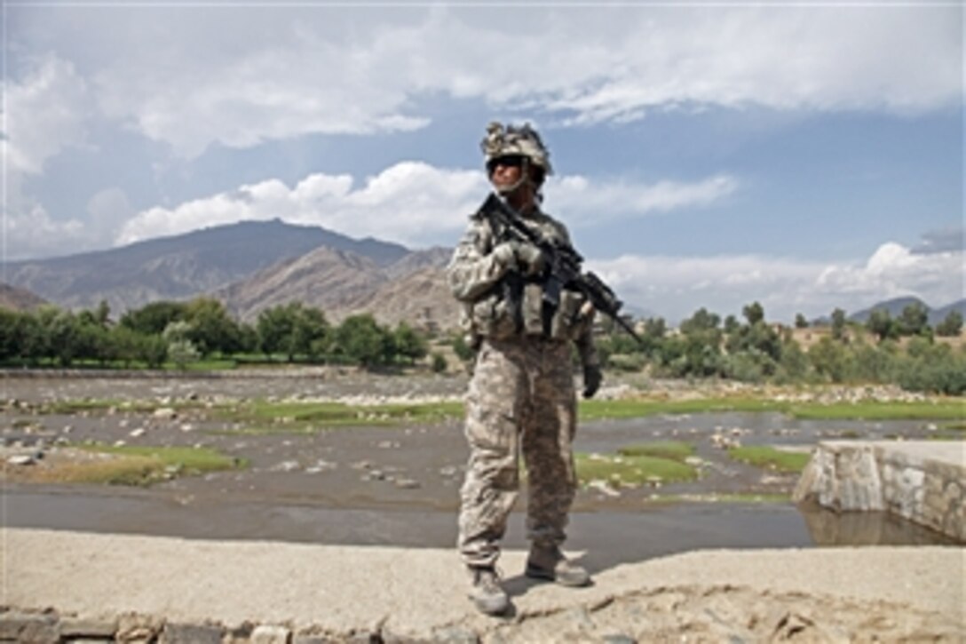 U.S. Army Staff Sgt. Michael Cruz, deployed with 1st Battalion, 32nd Infantry Regiment, stands along the bank of the Pech River during a patrol through the streets of Asadabad city, Konar province, Afghanistan, on Aug. 19, 2009.  
