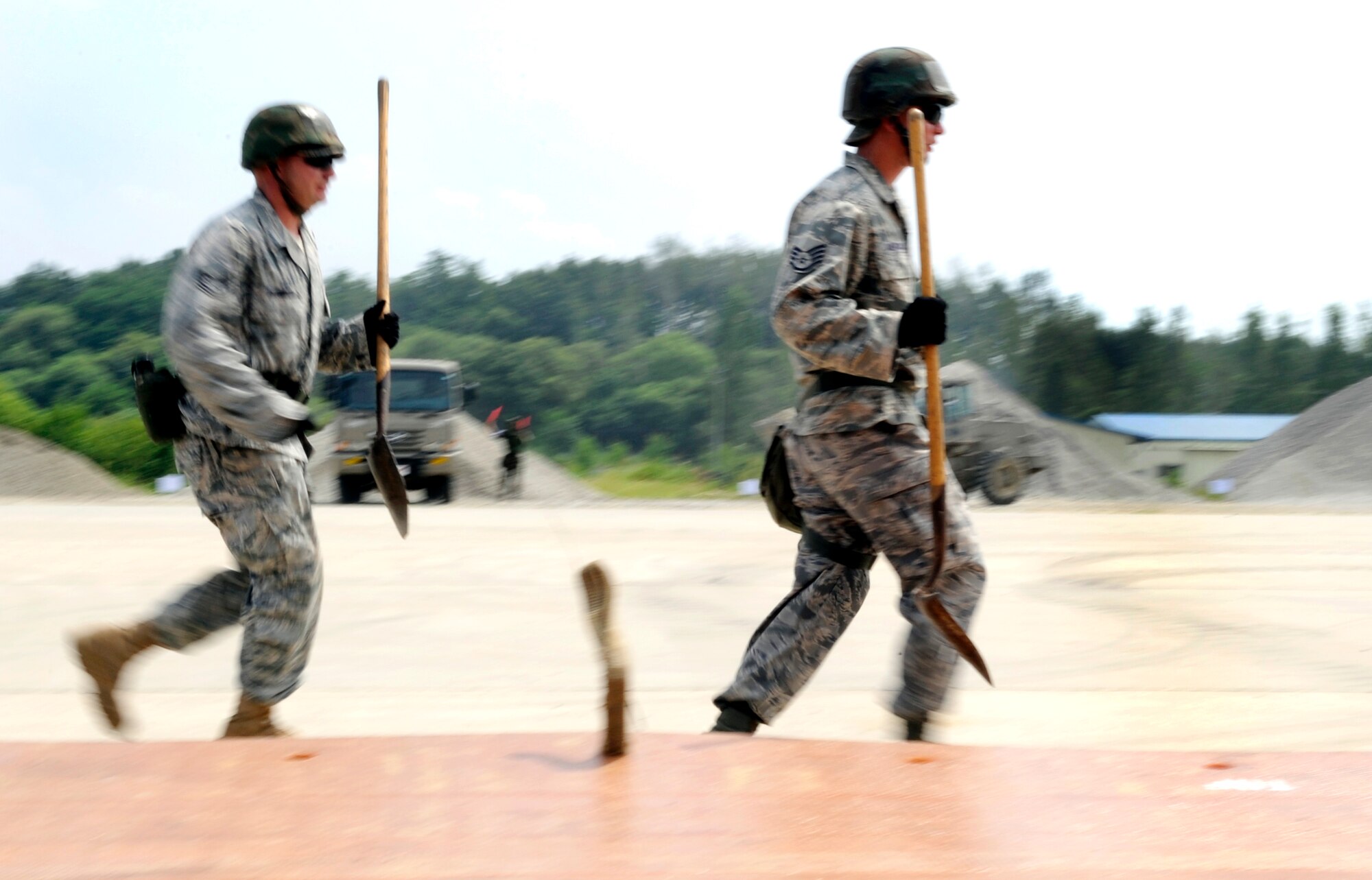 Staff Sgt. Tony Anderson, right, and Technical Sgt. Robert Barnett run to assist in moving of a folded fiberglass mat at Jungwon Air Base, Republic of Korea Aug 19. The Airmen are a part of a joint combined rapid runway repair training exercise with Airmen from the Republic of Korea Air Force's 19th Tactical Fighter Wing and 91st Air Civil Engineer Group.  Sergeants Anderson and Barnett are assigned to the 51st Civil Engineer Squadron, Osan Air Base, Republic of Korea. (U.S. Air Force photo/ Senior Airmen Stephenie Wade)
