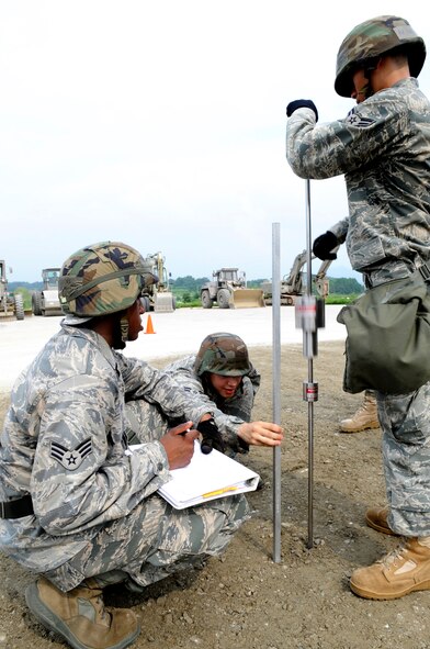Senior Airman Christopher Davis, left, Airman 1st Class Jason Alfaro, center, and Airman 1st Class Chi Li test the compaction of a filled crater using a dynamic cone pentrometer at Jungwon Air Base, Republic of Korea, Aug. 19.  The reading tells if the crater is sufficiently filled and compacted to withstand aircraft landings. This process was part of a joint combined rapid runway repair training exercise with Airmen from the Republic of Korea Air Force's 19th Tactical Fighter Wing and 91st Air Civil Engineer Group.  Airmen Davis, Alfaro and Chi Li are assigned to the 51st Civil Engineer Squadron, Osan Air Base, Republic of Korea. (U.S. Air Force photo/Senior Airmen Stephenie Wade)
