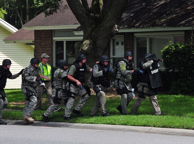 Members of the Summerville Emergency Services Unit advance toward a home on East Jackson Drive here Aug. 21 during a training scenario with members of the 437th Security Forces Squadron. Airmen from the 437 SFS acted as aggressors taking shelter in one of the vacant homes. The training was coordinated by the Office of Special Investigations here, fostering continued coordination between Charleston AFB and the local law enforcement community. (U.S. Air Force photo/Staff Sgt. Daniel Bowles)