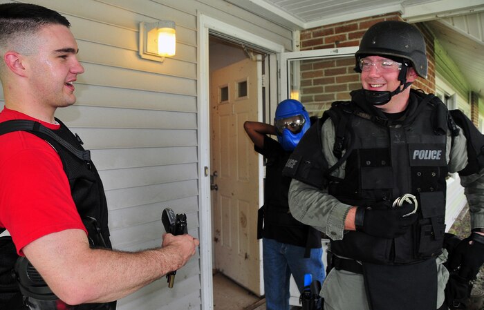 Airman 1st Class Aaron Zelenka talks with Cpl. Rick Gebhardt after being apprehended and released in an exercise with the Summerville Emergency Services Unit here Aug. 21. Airman Zelenka acted as an aggressor in a use of force training scenario. Airman Zelenka is an entry controller with the 437th Security Forces Squadron and Gebardt is a detective with the Summerville Emergency Services Unit. (U.S. Air Force photo/Staff Sgt. Daniel Bowles)