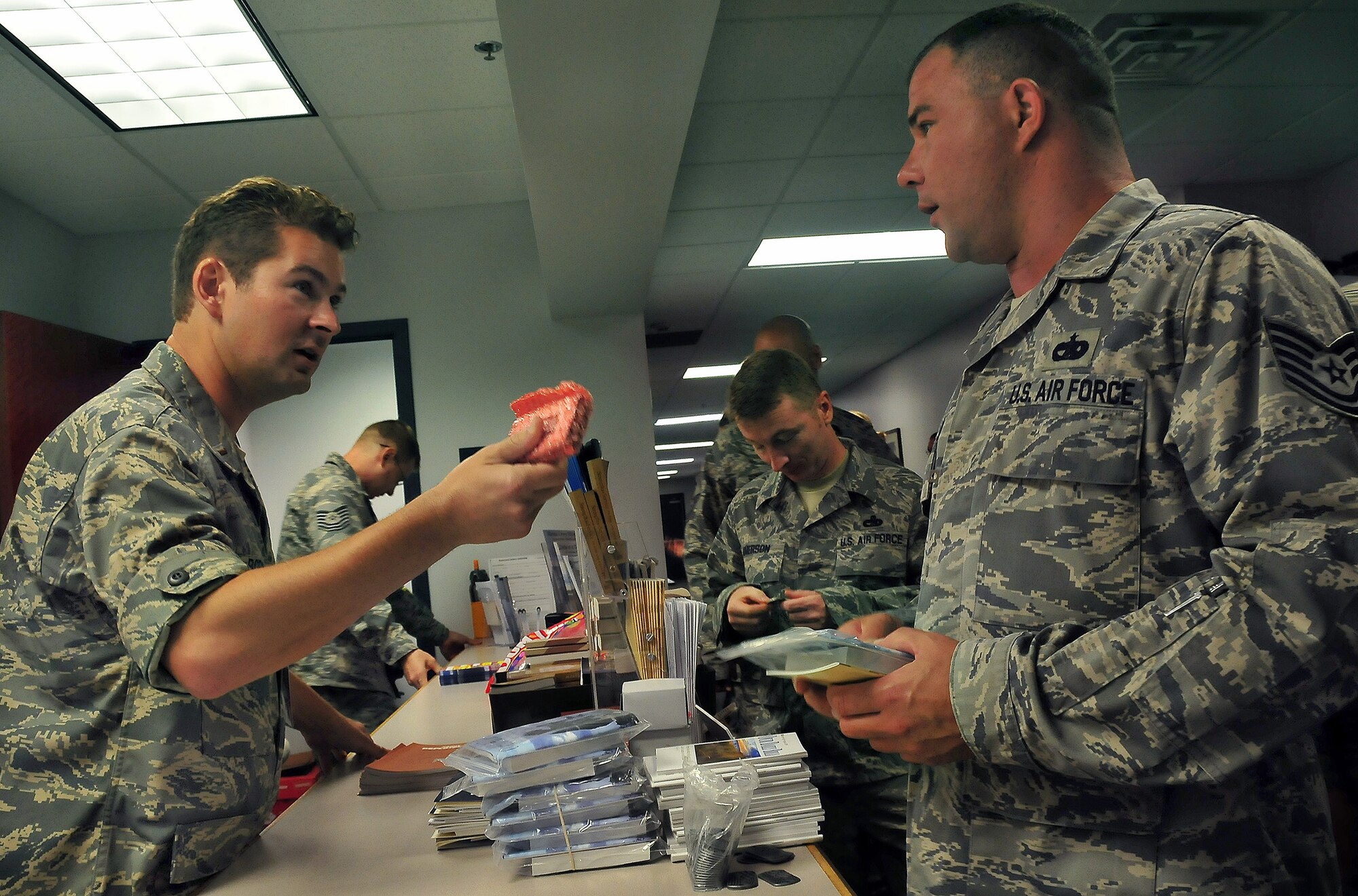 2nd Lt. Tom Boeger offers a digital audio player filled with various sermons to Tech. Sgt. Kory Kearney during a deployment processing line at Building 610 here Aug. 20. The 437th Airlift Wing chaplain staff offers more than 20 different books, pamphlets and handouts at each processing line to help Airmen meet their spiritual needs while deployed. Lieutenant Boeger is a chaplain candidate with the Utah Air National Guard and Sergeant Kearney is the NCO in charge of equipment support with the 437th Logistics Readiness Squadron. (U.S. Air Force photo/Staff Sgt. Daniel Bowles)