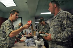 Second Lt. Tom Boeger offers a digital audio player filled with various sermons to Tech. Sgt. Kory Kearney during a deployment processing line at Building 610 here Aug. 20. The 437th Airlift Wing chaplain staff offers more than 20 different books, pamphlets and handouts at each processing line to help Airmen meet their spiritual needs while deployed. Lieutenant Boeger is a chaplain candidate with the Utah Air National Guard and Sergeant Kearney is the NCO in charge of equipment support with the 437th Logistics Readiness Squadron. (U.S. Air Force photo/Staff Sgt. Daniel Bowles)