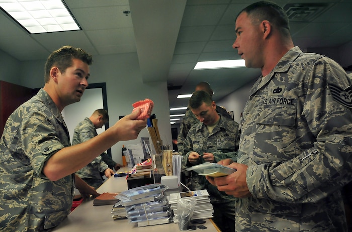 2nd Lt. Tom Boeger offers a digital audio player filled with various sermons to Tech. Sgt. Kory Kearney during a deployment processing line at Building 610 here Aug. 20. The 437th Airlift Wing chaplain staff offers more than 20 different books, pamphlets and handouts at each processing line to help Airmen meet their spiritual needs while deployed. Lieutenant Boeger is a chaplain candidate with the Utah Air National Guard and Sergeant Kearney is the NCO in charge of equipment support with the 437th Logistics Readiness Squadron. (U.S. Air Force photo/Staff Sgt. Daniel Bowles)