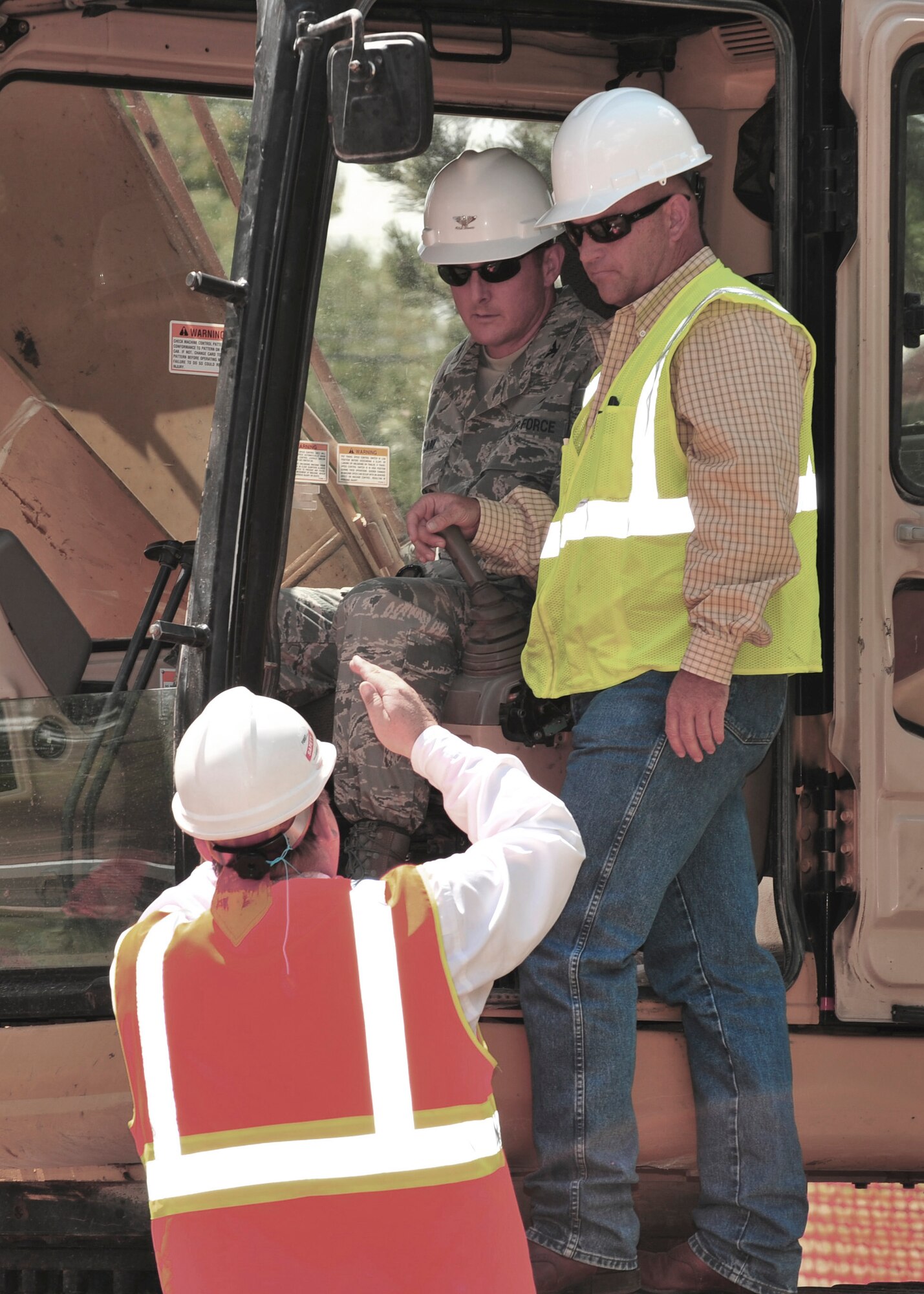 CANNON AIR FORCE BASE, N.M. -- Col. Stephen Clark, 27th Special Operations Wing commander, receives demolition instruction from members of the U.S. Army Corps of Engineer here, Aug. 24. Colonel Clark pulled down the first portion of   Dormitory 1256 using a track-hoe. The dorm is one of three that will be demolished. (U.S. Air Force photo by Senior Airman Erik Cardenas)                                                                                       