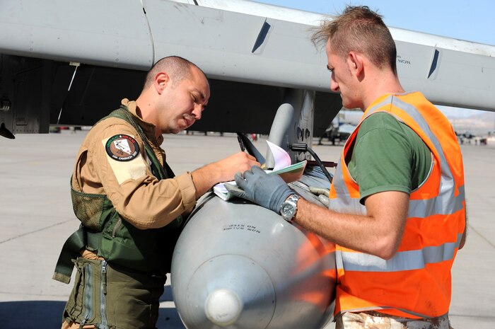NELLIS AIR FORCE BASE Nev.-- Italian Air Force Capt. Prudente Alfonso fills out pre-flight paperwork, with Crew Chief, Master Sgt. Alex Biancardi before climbing into an AMX/ A-1 fighter for a training mission at Red Flag 09-5 Aug. 24. Before flying in Red Flag, the Italian Air Force participated in their first ever Green Flag—a realistic close air support training exercise for Airmen and Soldiers preparing to deploy in support of combat operations in Southwest Asia. During the two-week exercise held Aug. 7-21, the Italian Air Force worked closely with U.S. Air Force joint terminal attack controllers embedded with the 3rd Infantry Division at Fort Irwin, Calif., to protect 6,000 Soldiers from an opposing enemy force in a 1,000-square-mile combat environment. Red Flag 09-5 ends Sept., 4. (U.S. Air Force Photo by Airman 1st Class Jamie Nicley) (Released)