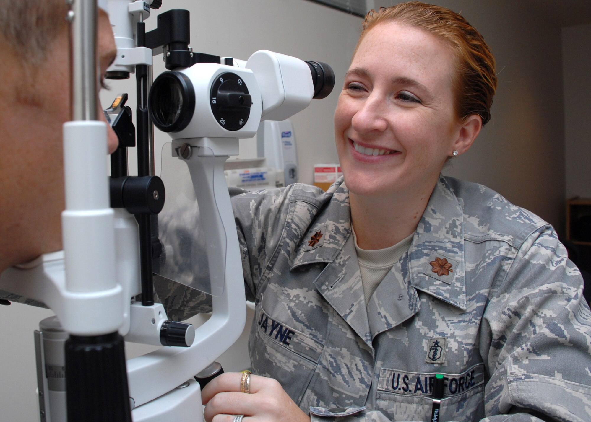 HICKAM AIR FORCE BASE, Hawaii -- Maj. Tara Jayne, 15th Aeromedical-Dental Squadron optometrist, uses a split lamp to determine the overall health of Senior Airman Matthew Brown?s. She has spent more than eight years as an optometrist in the Air Force providing eye care and teaching people that wearing sunglasses can prevent cataracts later in life. Major Jayne, the only Air Force optometrist on Hickam, has been on five humanitarian trips to the Dominican Republic, Philippines and Thailand during her career. Her next assignment will take her to Europe and Ramstein Air Base, Germany. (U.S. Air Force photo by Staff Sgt. Mike Meares)