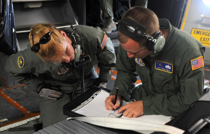 712th Aircraft Maintenance Squadron members Tech. Sgt. Athena Mercer and Staff Sgt. Ryan Smith complete their maintenance checklists prior to take off Aug. 22. They were part of the crew to visit the 8 Wing Canadian Forces Base Trenton in Ontario Aug. 22-24. The purpose of the first 512th Airlift Wing visit to the 8 Wing was to forge a partnership and identify future training opportunities for flying, aerial port, airlift control and maintenance operations. (U.S. Air Force photo/Capt. Marnee A.C. Losurdo)