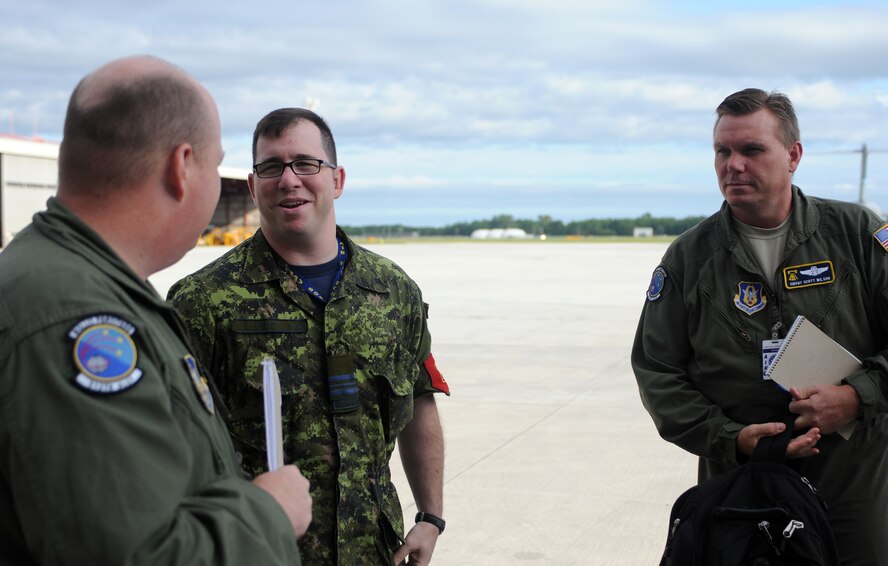 Master Sgt. Henry Fortney, 512th Airlift Control Flight loadmaster, left, and Senior Master Sgt. Scott Wilson, 512th ALCF superintendent, met with Canadian Air Force Maj. Aaron Spott, 2 Air Movements Squadron commanding officer Aug. 24 at 8 Wing Canadian Forces Base Trenton, 2 miles northeast of Trenton, Ontario. The purpose of the first 512th Airlift Wing visit Aug. 22 -24 was to forge a partnership with the Canadian wing to identify future training opportunities for flying, aerial port, airlift control and maintenance operations. (U.S. Air Force photo/Capt. Marnee A.C. Losurdo)