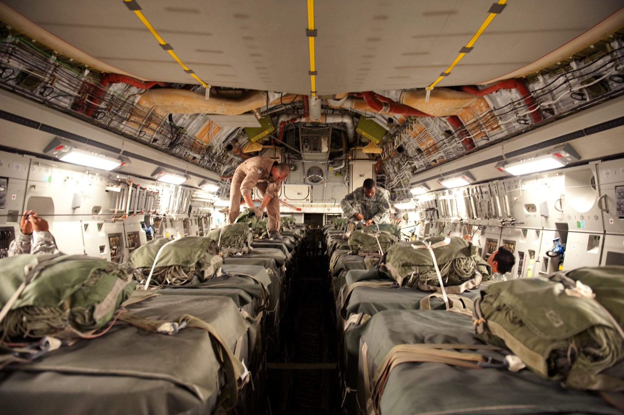 Left, Staff Sergeant Chris Baker, 817th Expeditionary Airlift Squadron loadmaster, and U.S. Army Pfc. Reginald Conner, Detachment 8-24th Quartermaster Company, 593rd Special Troop Battalion joint airdrop inspector, check parachutes on aerial drop loads, Aug. 12, in Southwest Asia. The cargo will be air dropped to military servicemembers throughout the U.S. Central Command area of responsibility.  Sergeant Baker is deployed from McChord Air Force Base, Wash., and Private Conner is deployed from Fort Bragg, N.C., in support of Operations Iraqi and Enduring Freedom. (U.S. Air Force Photo/Staff Sgt. Robert Barney)