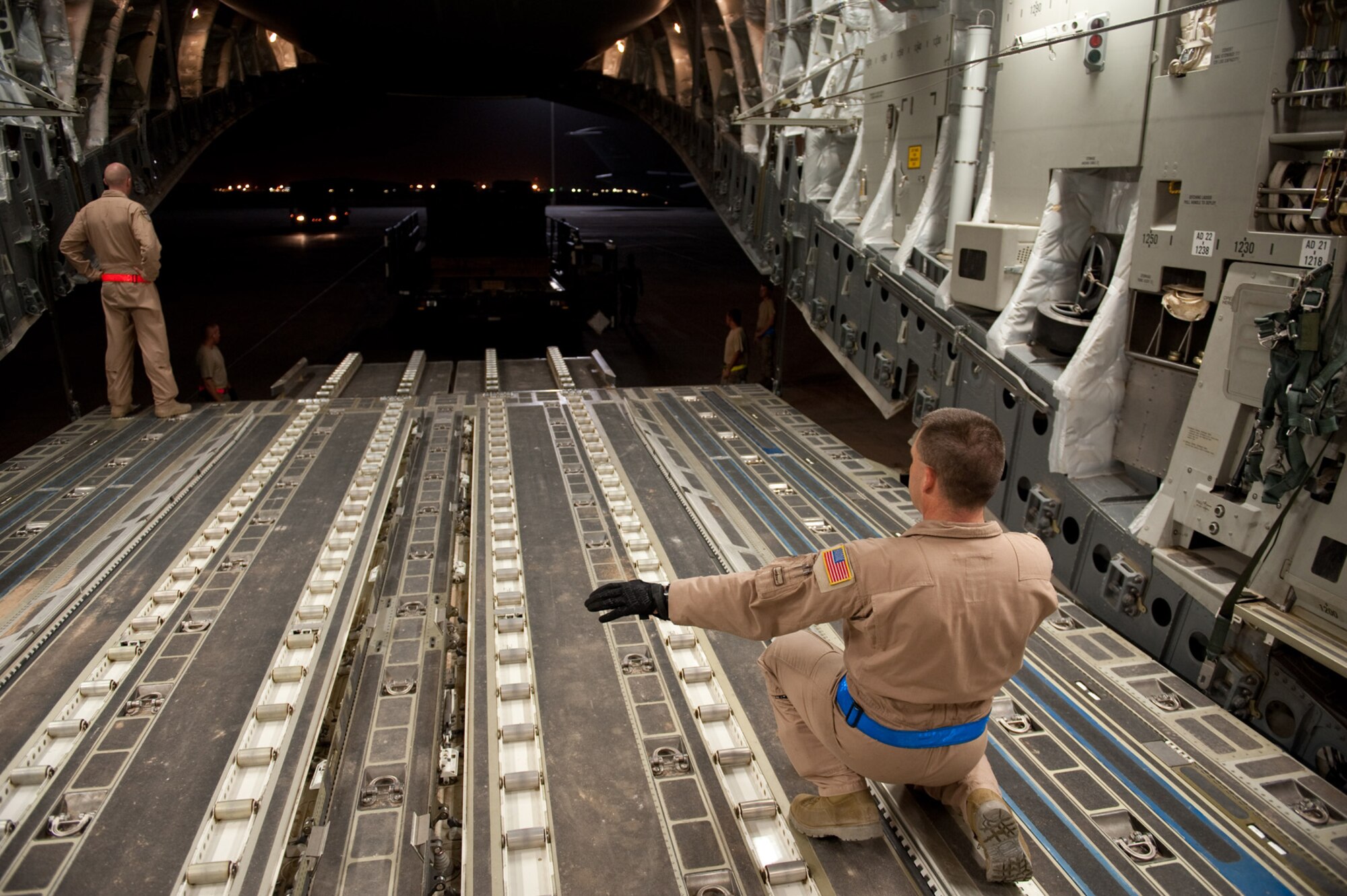 Senior Master Sgt. Lou Orrie, 817th Expeditionary Airlift Squadron loadmaster, directs a K-loader to the back of a C-17 Globemaster III as it prepares to receive drop loads, Aug. 12, in Southwest Asia. The cargo will be air dropped to military servicemembers throughout the U.S. Central Command area of responsibility. Sergeant Orrie is deployed from McChord Air Force Base, Wash., in support of Operations Iraqi and Enduring Freedom. (U.S. Air Force Photo/Staff Sgt. Robert Barney)