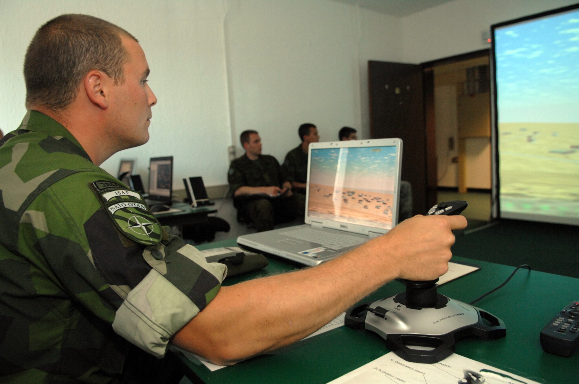 Swedish army ranger Capt. Timothy Walsh, a forward air controller, practices using the joystick for the computer simulator used for practicing air strikes during close air support operations at the U.S. Air Forces in Europe Air Ground Operations School. Captain Walsh and two Estonian air force members spent a week in pre-deployment briefings, computer simulation, and field training prior to deployment thanks to the joint efforts of the staff at the USAFE AGOS and the International Security Assistance Force Cell at NATO Allied Air Component Command Headquarters Ramstein Aug. 17- 21. (U.S. Air Force photo/Master Sgt. Corey Clements)