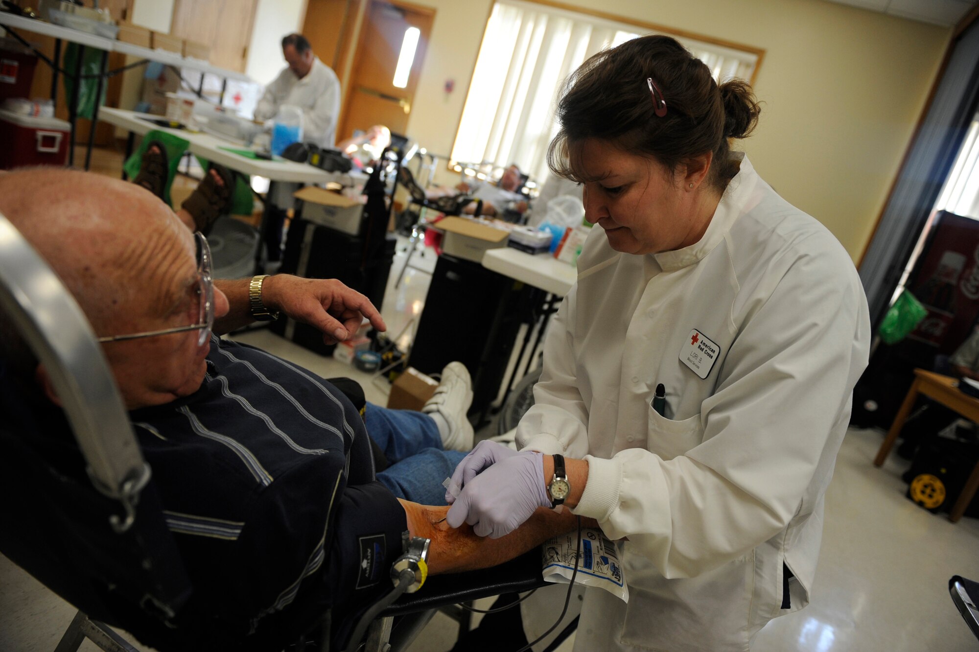 MOUNTAIN HOME AIR FORCE BASE, Idaho -- Lori Barkes, Red Cross technician, inserts a needle into a blood donor Aug. 19 at the base chapel. The 366th Fighter Wing hosted a blood drive for the American Red Cross and collected 113 units of blood, beating the previous record of blood donated in one day by three. (U.S. Air Force photo by Airman 1st Class Renishia Richardson)