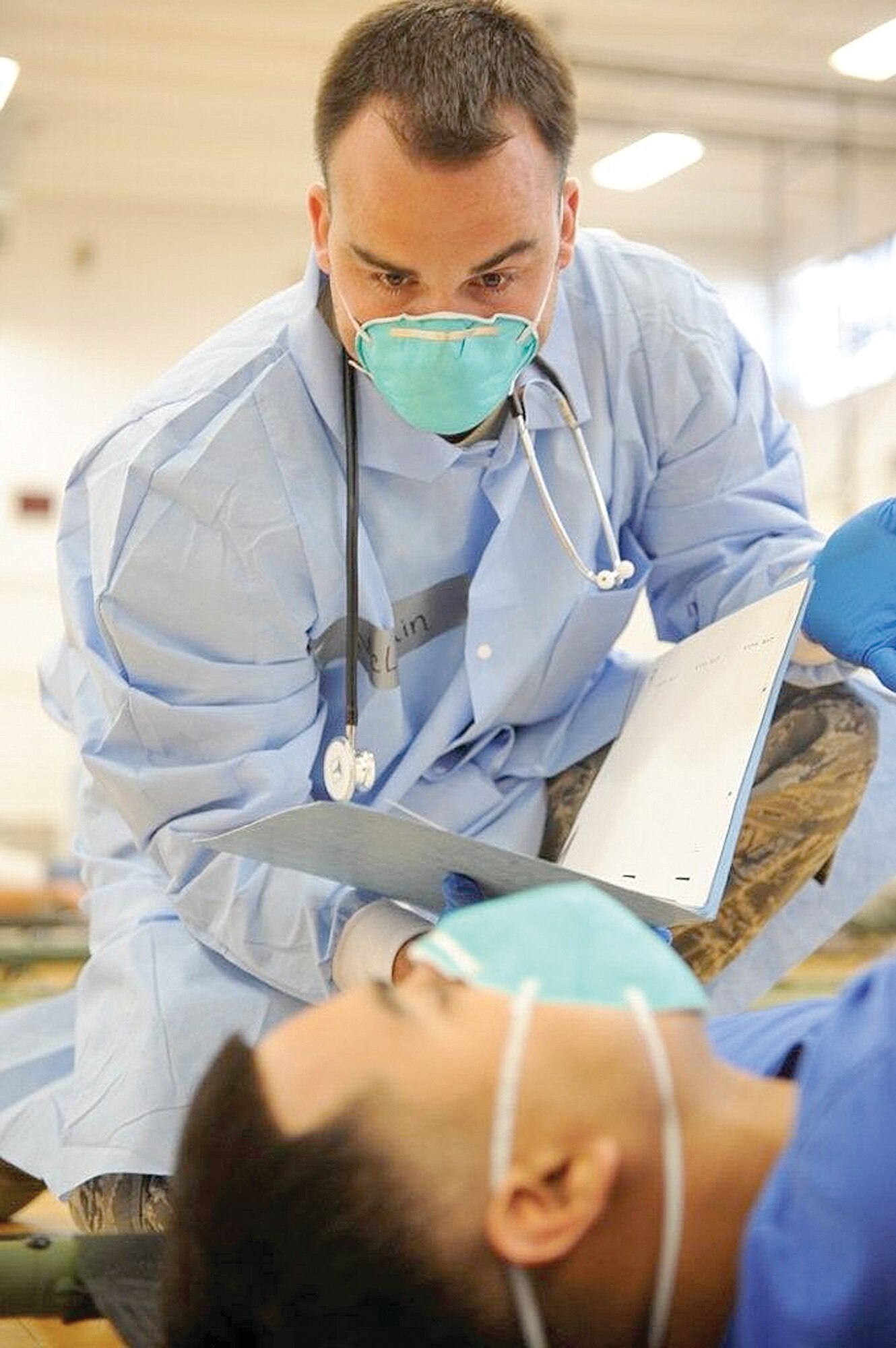 Airman 1st Class Brandon McLaughlin, of the 75th Medical Operations Squadron, evaluates a “patient” during an H1N1 disease containment exercise conducted by his squadron Aug. 12. USAF photo by James Arrowood