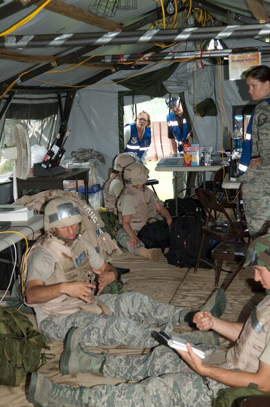 HANSCOM AIR FORCE BASE, Mass. –Congresswoman Niki Tsongas gets a glimpse of Airmen in the Acquisition Unit Control Center tent taking appropriate measures to protect themselves during an Alarm Blue, ground attack at Camp Patriot as part of a base readiness exercise.  Congresswoman Tsongas, who represents the fifth Congressional District of Massachusetts, visited Hanscom on Aug. 21, touring Camp Patriot operations, the 66th Medical Group, and the Child Development Center. (U.S. Air Force photo by Rick Berry)