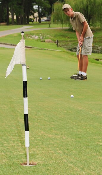 Weston Straw, son of Lt. Col. Wayne Straw, 4th Operations Group deputy commander, practices his putt before beginning the Three Eagles Golf Course grand re-opening putting tournament on Seymour Johnson Air Force Base, N.C., Aug. 21, 2009. The course's fairways were replanted with sprigs of hybrid Bermuda grass making for good year round playing conditions. (U.S. Air Force photo by Airman 1st Class Rae Perry)