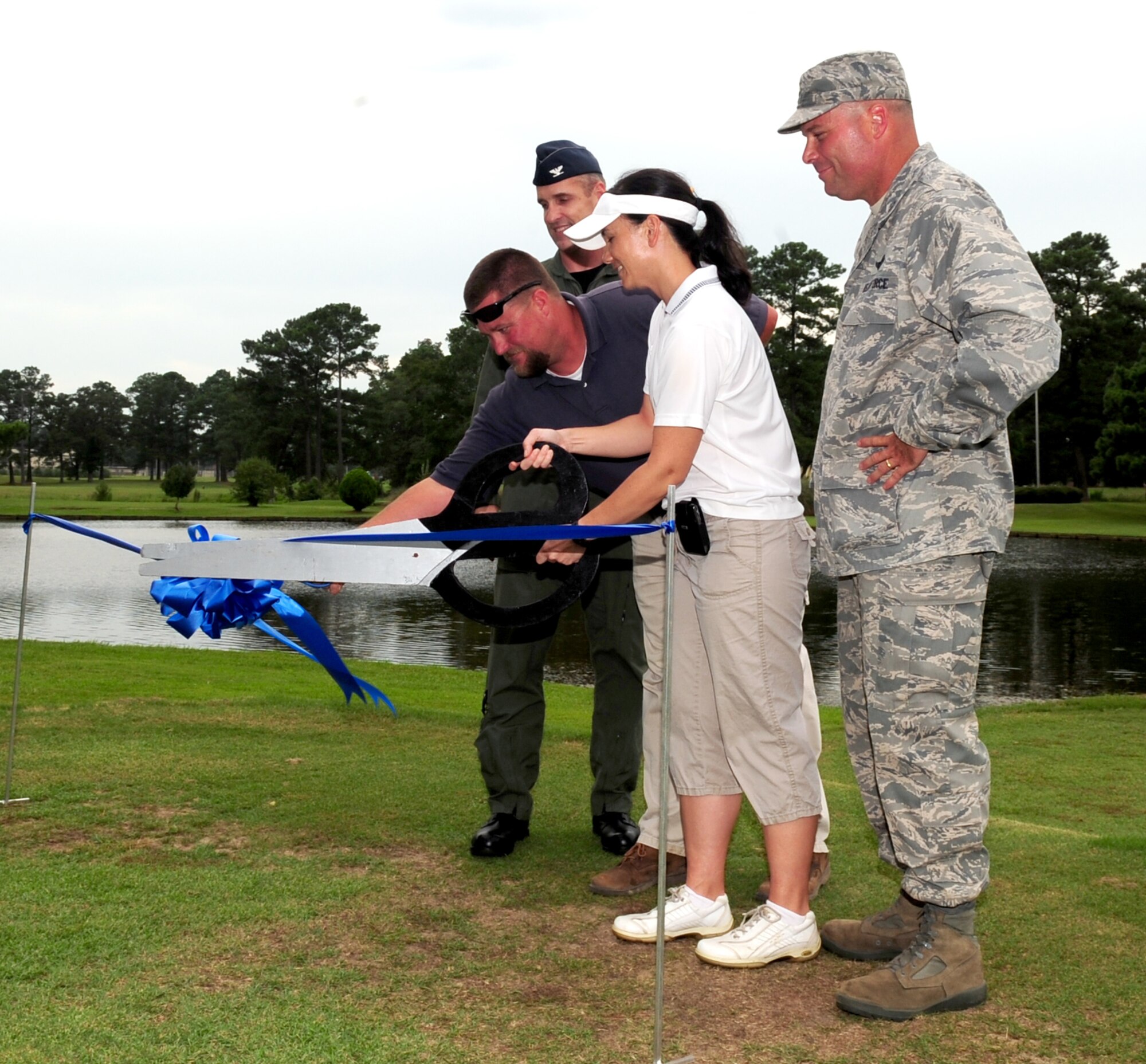Col. John Hruby, 4th Operations Group commander, Chad Barns, Three Eagles Golf Course superintendant, Maj. Debra Lovette, 4th Force Support Squadron commander, and Col. William Thomas, 4th Mission Support Group commander, cut the ceremonial ribbon, re-opening the Three Eagles Golf Course at Seymour Johnson Air Force Base, N.C., Aug. 21, 2009. The golf course was closed June 15 to revamp the tee boxes, fairways and sand traps to improve the quality of the course. (U.S. Air Force photo by Airman 1st Class Rae Perry)
