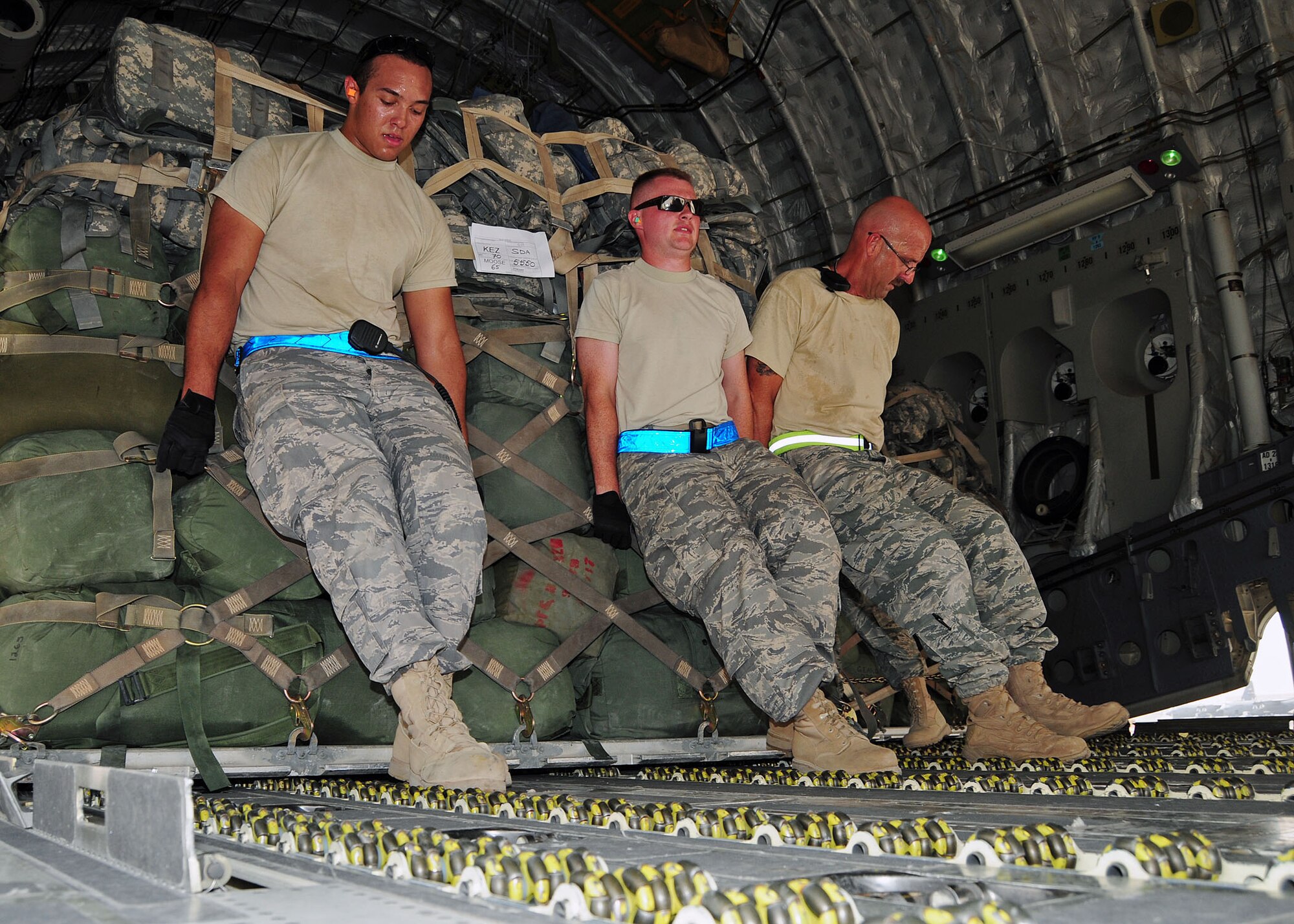 SOUTHWEST ASIA -- (From left to right), Airman 1st Class Bryce Cobert, 386th Expeditionary Logistics Readiness Squadron ramp services specialist, Tech. Sgt. Michael Peppers, 386th ELRS Air Terminal Operation Center member, and Tech. Sgt. Anthony Marucci, 386th ELRS ramp services team chief, move a cargo pallet into position aboard a C-17 Globemaster III on the 386th Air Expeditionary Wing parking ramp at an undisclosed location in Southwest Asia Aug. 21, 2009.  Airman Cobert is deployed from the 60th Air Mobility Wing, Travis Air Force Base, Calif., Sergeant Peppers is deployed from the 914th Airlift Wing, Niagara Falls Air Reserve Station, N.Y., and Sergeant Marucci is deployed from the 70th Aerial Port Squadron, Homestead Air Reserve Base, Fla.  (U.S. Air Force photo/Tech. Sgt. Tony Tolley)