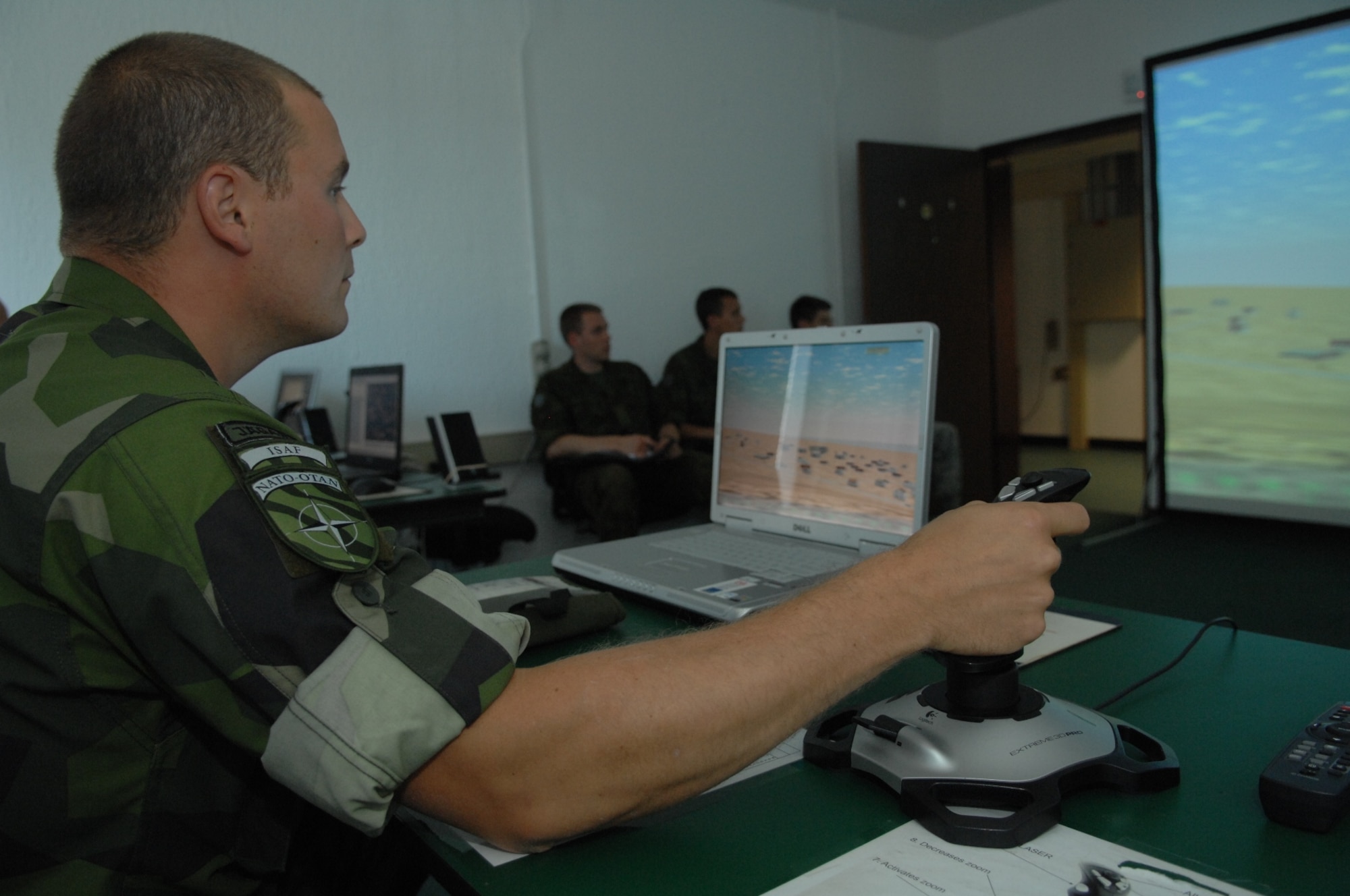 RAMSTEIN AIR BASE, Germany- Swedish army ranger, Capt. Timothy Walsh, a forward air controller, practices using the joystick for the computer simulator used for practicing air strikes during close air support operations at the U.S. Air Forces in Europe Air Ground Operations School.  Capt Walsh and two Estonian air force members spent a week in pre-deployment briefings, computer simulation, and field training prior to deployment thanks to the joint efforts of the staff at the USAFE AGOS and the International Security Assistance Force Cell at NATO Allied Air Component Command Headquarters Ramstein Aug. 17- 21. (U.S. Air Force photo/Master Sgt. Corey Clements)