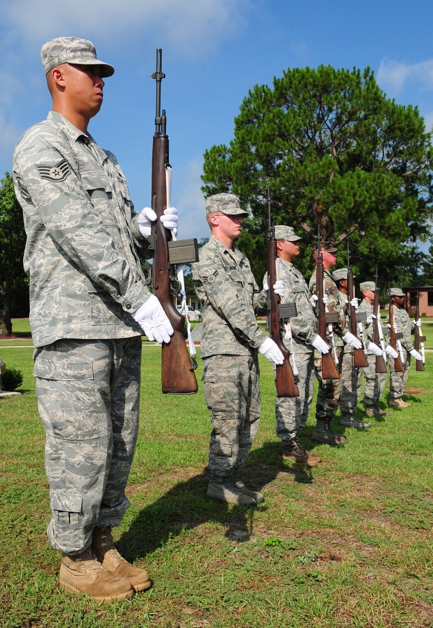 Honor guard Airmen from the 4th Fighter Wing and the Charlotte Air National Guard firing party stand at attention during a simulated military funeral ceremony at Seymour Johnson Air Force Base, N.C. Aug. 19, 2009. The firing party primarily uses the M-14 Automatic Rifle that can date it's lineage back to the M1 used by United States troops in World War II. The M-14 weighs approximately 12 pounds. (U.S. Air Force photo by Airman 1st Class Rae Perry)