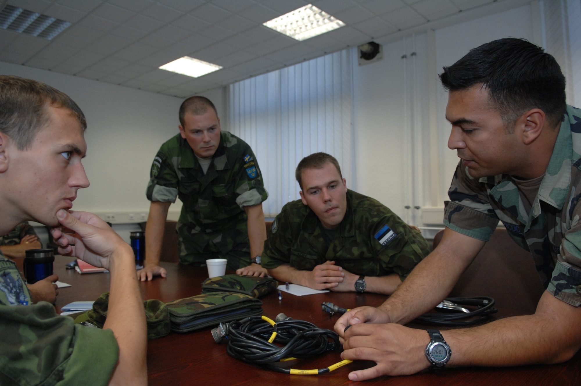 RAMSTEIN AIR BASE, Germany- Tech. Sgt. Nicholas Picoc (right), who is in charge of training and evaluations at the U.S. Air Forces in Europe Air Ground Operations School, showed international forward air controllers upgrades to the ROVER III, a kit which mainly consists of a tactical laptop, antennas, cables and other items used to receive live video feed from aircraft during close air support operations.  Two Estonian air force members and a Swedish army ranger spent a week in pre-deployment briefings, computer simulation, and field training prior to deployment thanks to the joint efforts of the staff at the USAFE AGOS and the International Security Assistance Force Cell at NATO Allied Air Component Command Headquarters Ramstein Aug. 17- 21.(U.S. Air Force photo/Master Sgt. Corey Clements)