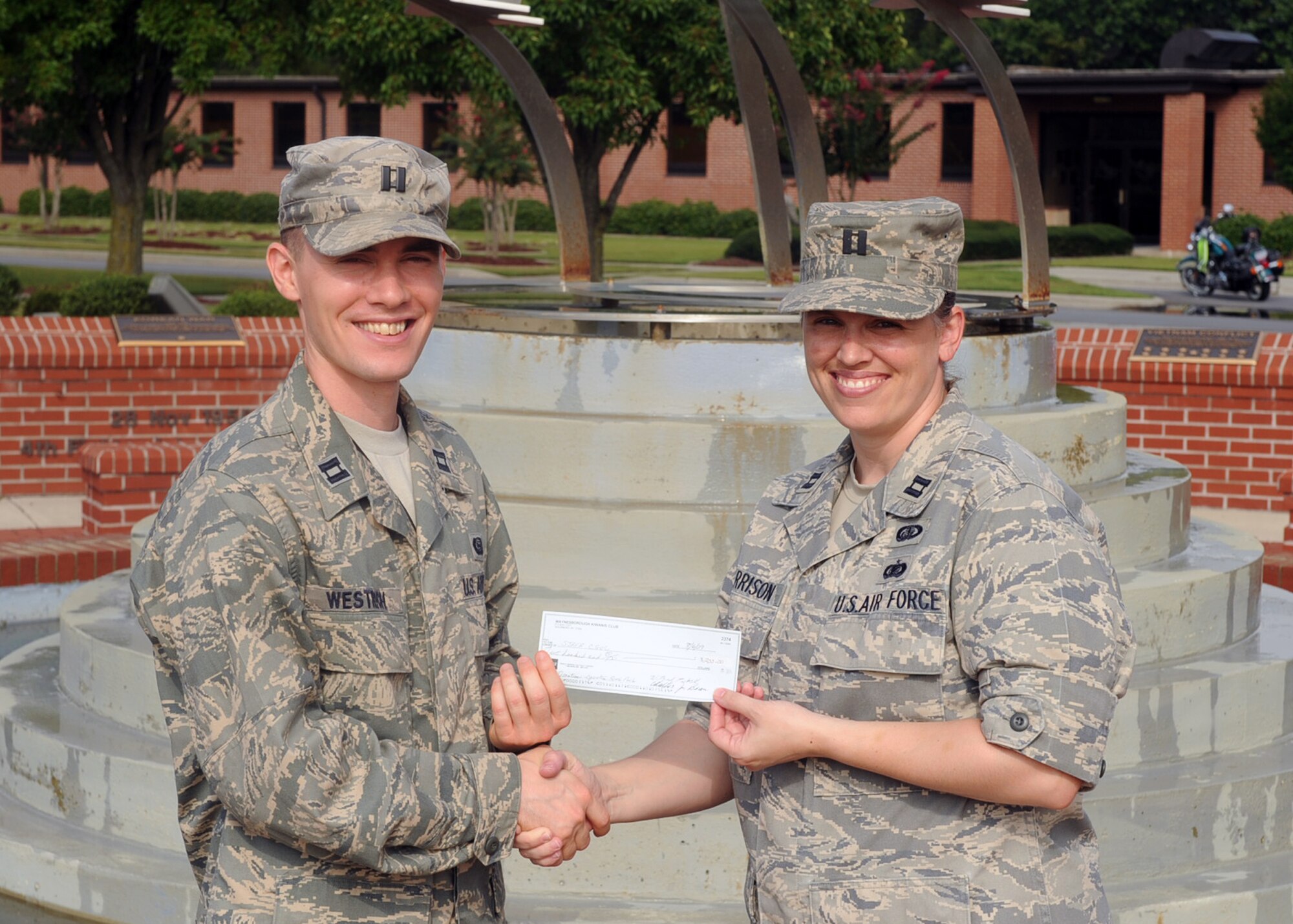 Capt. Michael Westrich, 4th Operations Support Squadron chief of targets, presents a $200 check to Capt. Julie Harrison, 4th Force Support Squadron manpower and personnel flight commander, from the Waynesborough Kiwanis Club for Operation Backpack, Aug. 19, 2009. Operation Backpack is a base-wide event to collect school supplies for local school children. The Seymour Johnson community is collecting school supplies until 31 August. (U.S. Air Force photo by Senior Airman Ciara Wymbs) 