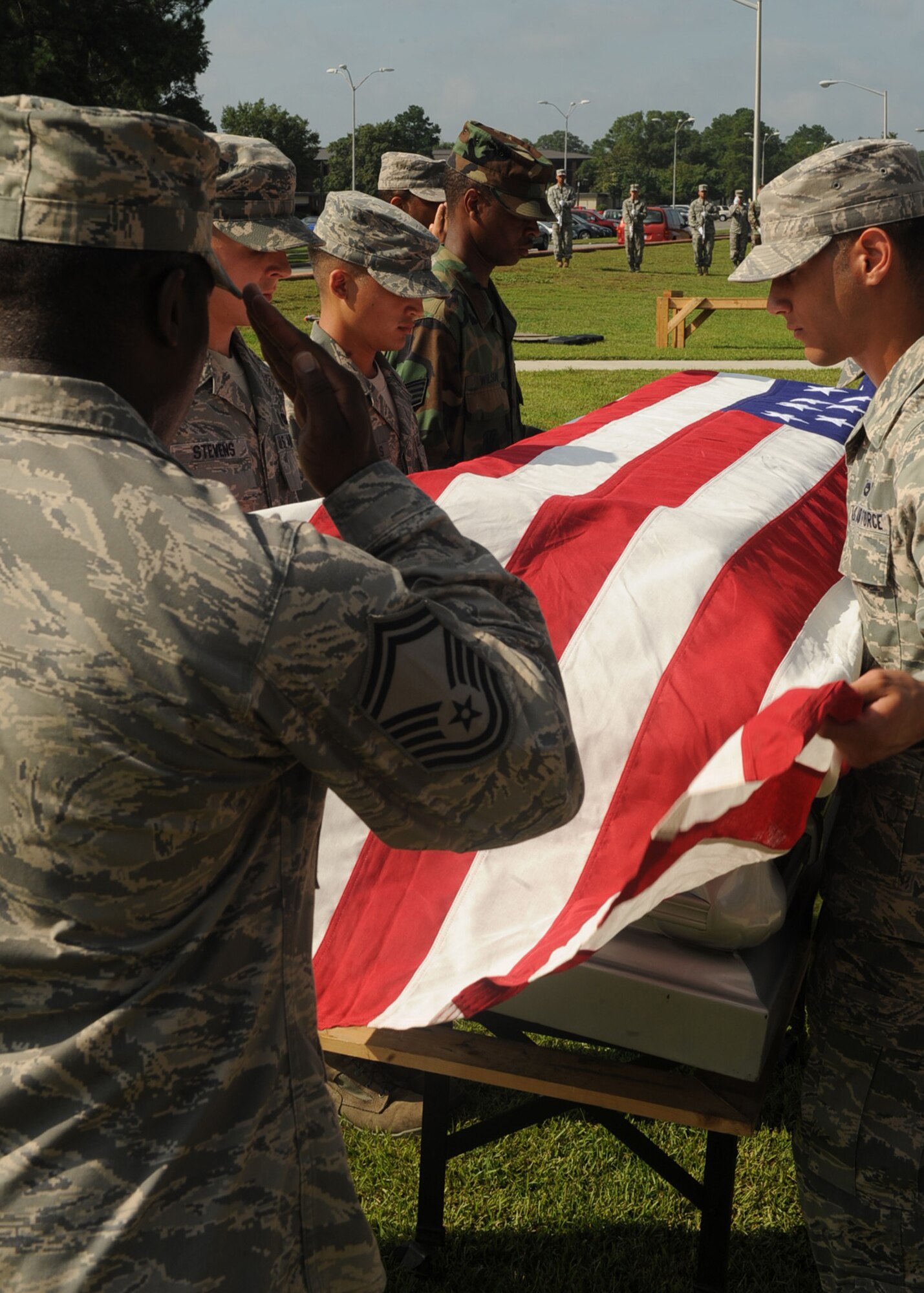 Senior Master Sgt. Marcus Williams, Charlotte Air National Guard, salutes a mock casket during an honor guard graduation ceremony at Seymour Johnson Air Force Base, N.C., Aug. 19, 2009. The Air Force honor guard member evaluated a 29-student class on how to properly conduct military customs during a funeral. (U.S. Air Force photo by Senior Airman Ciara Wymbs)  