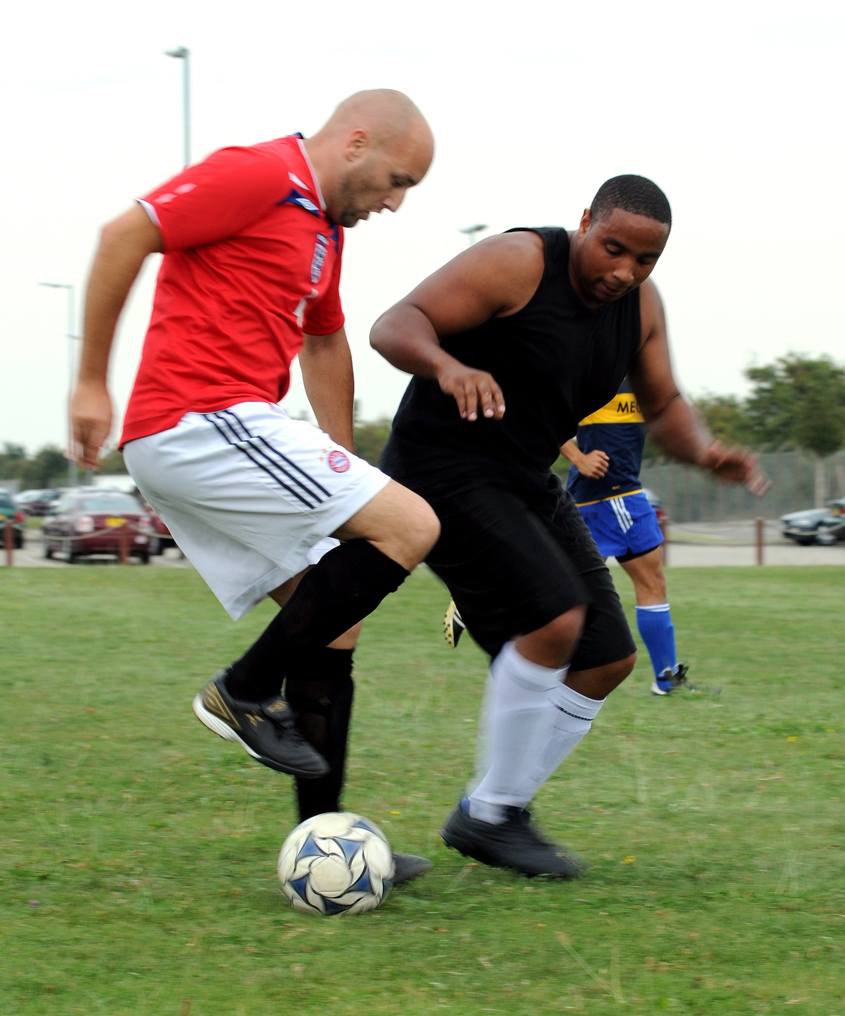 RAF MILDENHALL, England -- Forward/goalie Pete Webb (left), 727th Air Mobility Squadron, attempts to edge out defender Johnathon Bailey, 100th Logistics Readiness Squadron, during their maiden Mildenhall Intramural Outdoor Soccer league game Aug. 24 at the southside soccer fields. Due to the 727th AMS' trivial five-player lineup, Webb pulled out of the goal to help play the seven-player strong 100th LRS. The 4-0 game was eventually called at halftime. Anyone interested in the league should contact the Northside Fitness Center at DSN 238-2349. (U.S. Air Force photo by Senior Airman Thomas Trower)