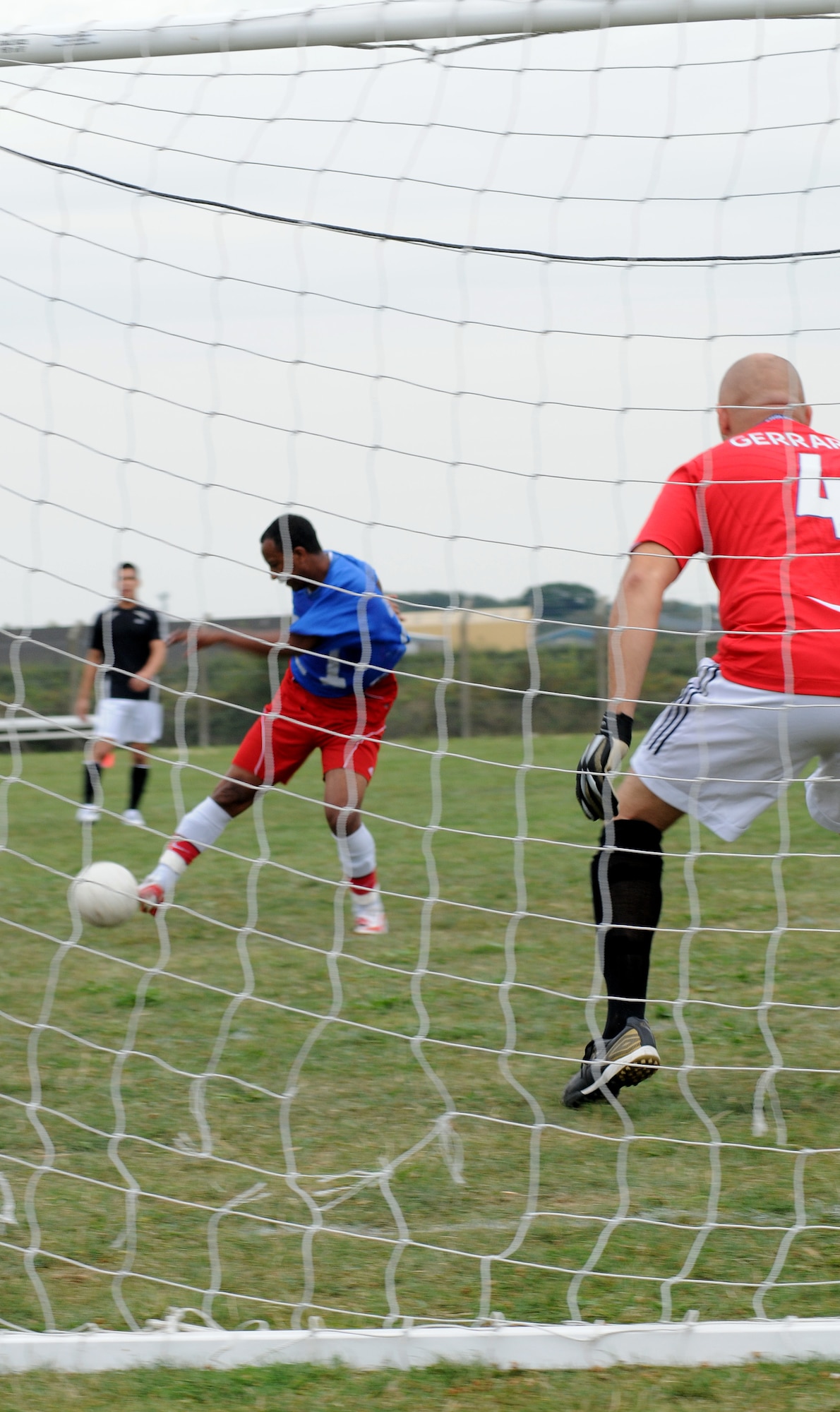 RAF MILDENHALL, England -- Striker Kibrom Retta, 100th Logistics Readiness Squadron, takes a shot against keeper Pete Webb, 727th Air Mobility Squadron, during the first day of play of the Mildenhall Intramural Outdoor Soccer season Aug. 24 at the southside soccer fields. Retta scored two of 100 LRS' four scores to punish the 727th AMS, who laid goose eggs. The game was called at halftime due to 727th AMS' lack of players. Anyone interested in the league should contact the Northside Fitness Center at DSN 238-2349. (U.S. Air Force photo by Senior Airman Thomas Trower)