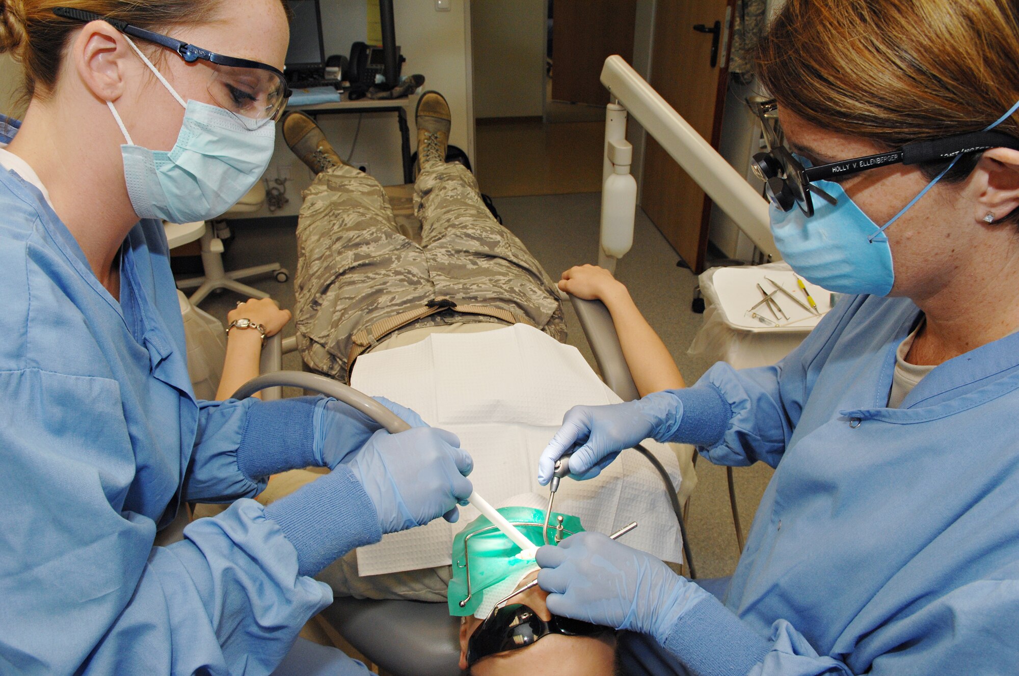 SPANGDAHLEM AIR BASE, Germany – Lt. Col. (Dr.) Holly Ellenburger (right) and Airman Amy Williams (left), both from the  52nd Dental Squadron, repair a cavity in the mouth of Senior Airman Mica Smith, 606th Air Control Squadron, Aug. 24. (U.S. Air Force photo/Senior Airman Benjamin Wilson)
