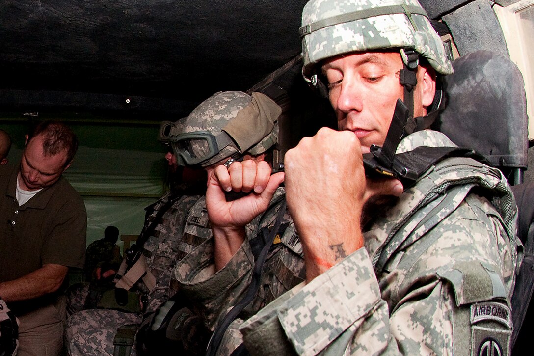 U.S. Army Sgt. 1st Class David Lowry, right, adjusts the helicopter-like harness in a
Caiman mine-resistant, ambush-protected vehicle rollover trainer on Camp Buehring, Kuwait, Aug. 22, 2009, before deploying in Anbar province, Iraq. Lowry is a civil affairs noncommissioned officer with the 82nd Airborne Division’s 1st Brigade Combat Team. Other soldiers in the rollover trainer are assigned to the 705th Military Police Battalion.