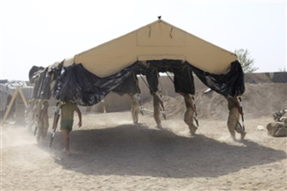U.S. Marines with Alpha Company, 1st Battalion, 5th Marine Regiment carry their tent to their living hole at the company's forward operating base in the Nawa district of Helmand province, Afghanistan, on Aug. 18, 2009.  The Marines are deployed with Regimental Combat Team 3 to conduct counterinsurgency operations with Afghan National Security Forces in southern Afghanistan.  