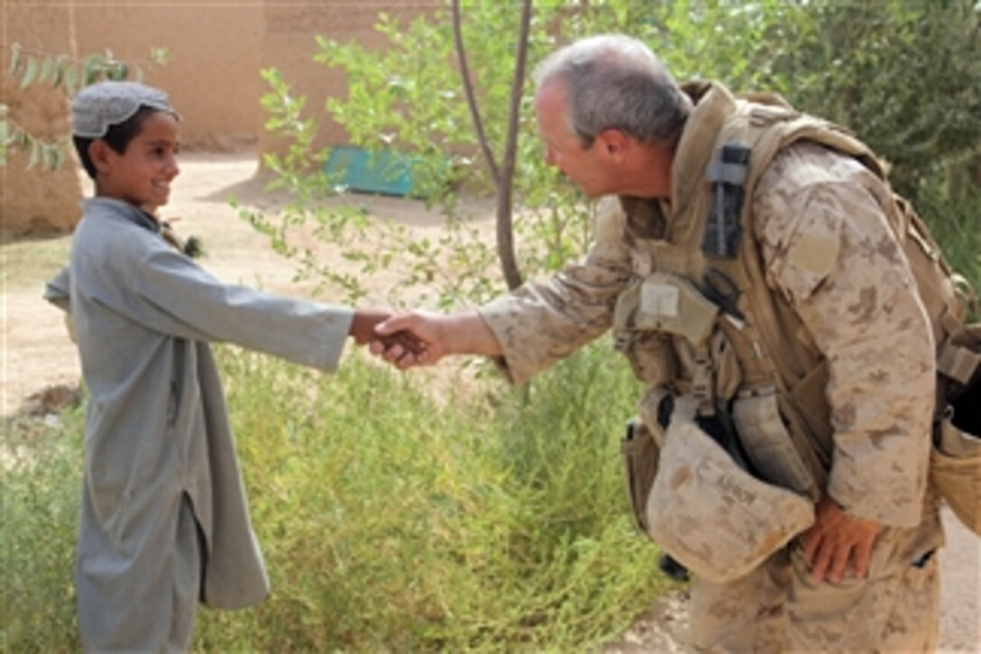 U.S. Navy Petty Officer 2nd Class William Lowry shakes hands with a boy during a census patrol in Helmand province, Afghanistan, on Aug. 18, 2009.  Delta Company, 2nd Amphibious Assault Battalion and civil affairs group Marines deployed with the 2nd Marine Expeditionary Brigade are talking with the local populace in order to understand their conditions and concerns and identify possible reconstruction and development projects.  Delta Company Marines are deployed with Regimental Combat Team 3, which is conducting counterinsurgency operations in partnership with Afghan security forces in southern Afghanistan.  