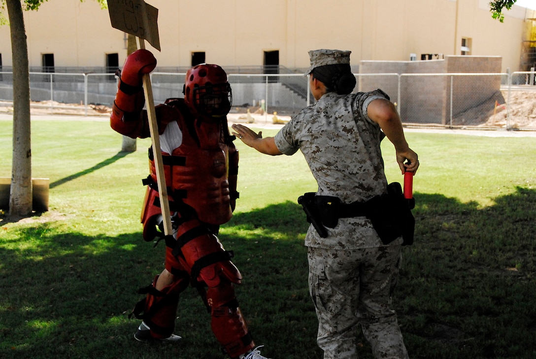 Lance Cpl. Dawn Doyle, right, military policeman, prepares to spray mock protestor Sean Huff, provost marshal’s office homeland security administrator, with fake pepper spray during escalation of force training at the Marine Corps Air Station in Yuma, Ariz., Aug. 25, 2009. The MPs practiced several scenarios, ranging from carrying out arrest warrants to responding to reports of domestic violence. “Every scenario was designed to cause them to respond with a different level of force,” said Terry Matzner, PMO training instructor.