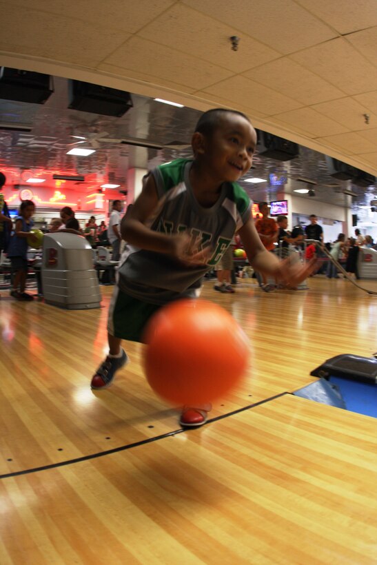 Five-year-old Devin Khaivilay throws a bowling ball down the lane Wednesday during Marine Unmanned Aerial Vehicle Squadron 1's back-to-school family fun day at the Combat Center's Sandy Hills Bowling Alley. Devin was only one of many children who took advantage of free bowling and pizza throughout the night.