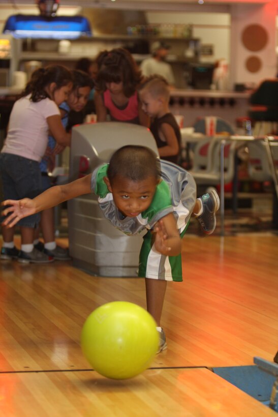 Five-year-old Devin Khaivilay throws a bowling ball down the lane Aug. 26 during Marine Unmanned Aerial Vehicle Squadron 1's back-to-school family fun day at the Combat Center's Sandy Hills Bowling Alley. Devin was only one of many children who took advantage of free bowling and pizza throughout the night.