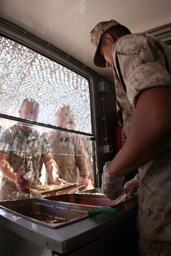Pfc. Ronal Pacheco, an engineer equipment operator with Marine Wing Support Squadron 374, serves food to fellow squadron Marines from the Field Food Service System at Camp Wilson Aug. 27. The FFSS was set up for the week to feed training Marines.