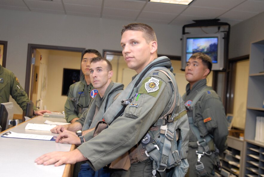 KUNSAN AIR BASE, Republic of Korea -- Kunsan and Korean ROK Air Force pilots receive a weather briefing before departing for their buddy wing flight here Aug. 26. The buddy wing flight program gives Kunsan pilots the chance of training and flying with their Korean counterparts. (U.S. Air Force photo/Staff Sgt. Darnell T. Cannady)