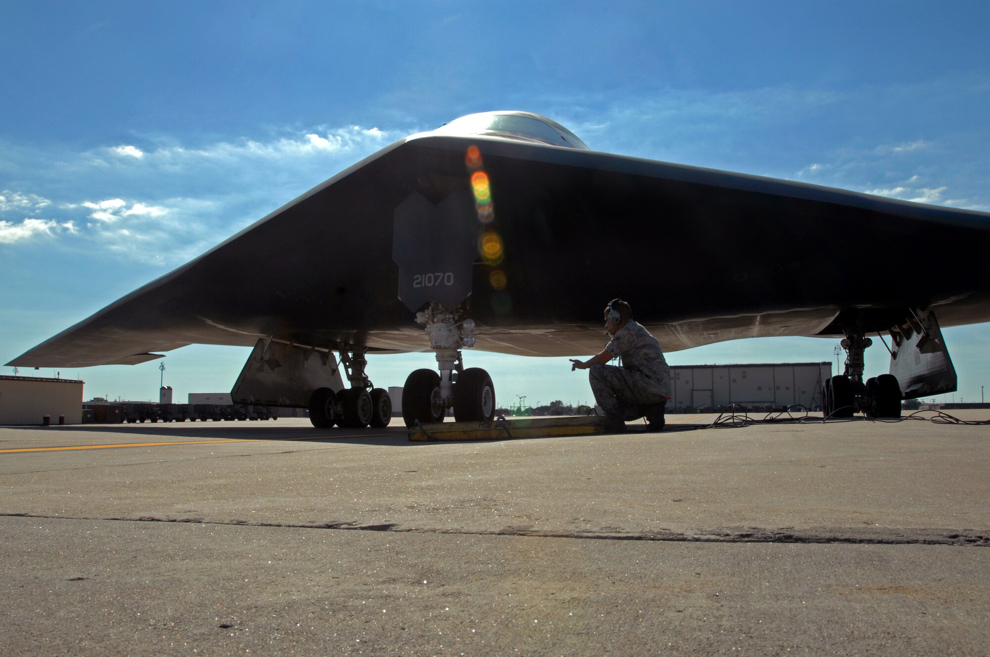 WHITEMAN AIR FORCE BASE, Mo. - Airman 1st Class Nathan Axelson, 509th Aircraft Maintenance Squadron crew chief, places chalks beneath a B-2 Spirit, Aug. 24. 509th AMXS crew chief work around the clock with B-2 pilots training and staying prepared for real world missions. (U.S. Air Force photo/Senior Airman Kenny Holston)