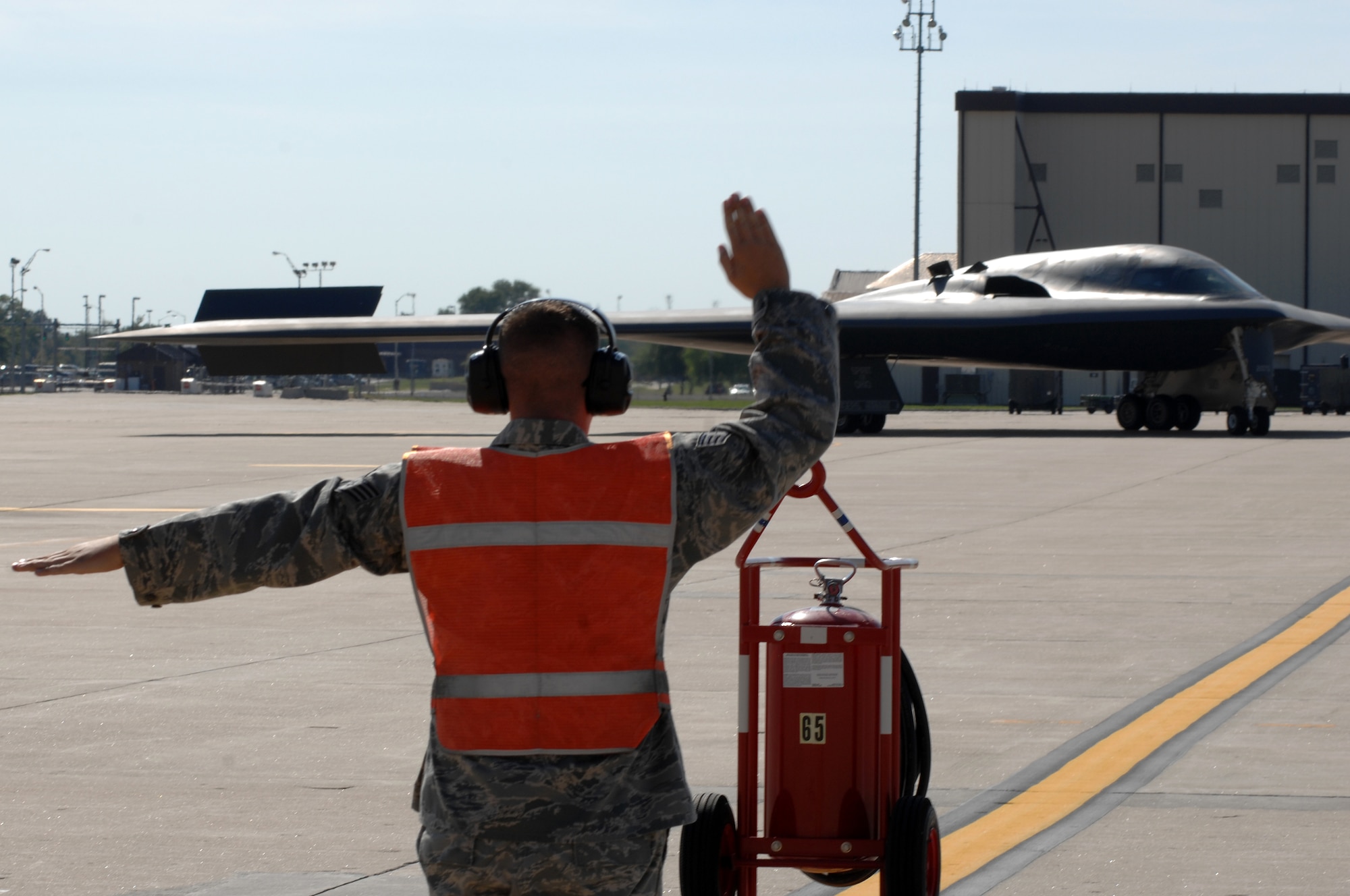 WHITEMAN AIR FORCE BASE, Mo.- Staff Sgt. Travis Wimberly, 509th Aircraft Maintenance Squadron crew chief, marshals a B-2 Spirit to its parking spot after returning from a mission, Aug. 24. 509th AMXS crew chiefs work around the clock with B-2 Spirit pilots training and staying prepared for real world missions. (U.S. Air Force photo/Senior Airman Kenny Holston)