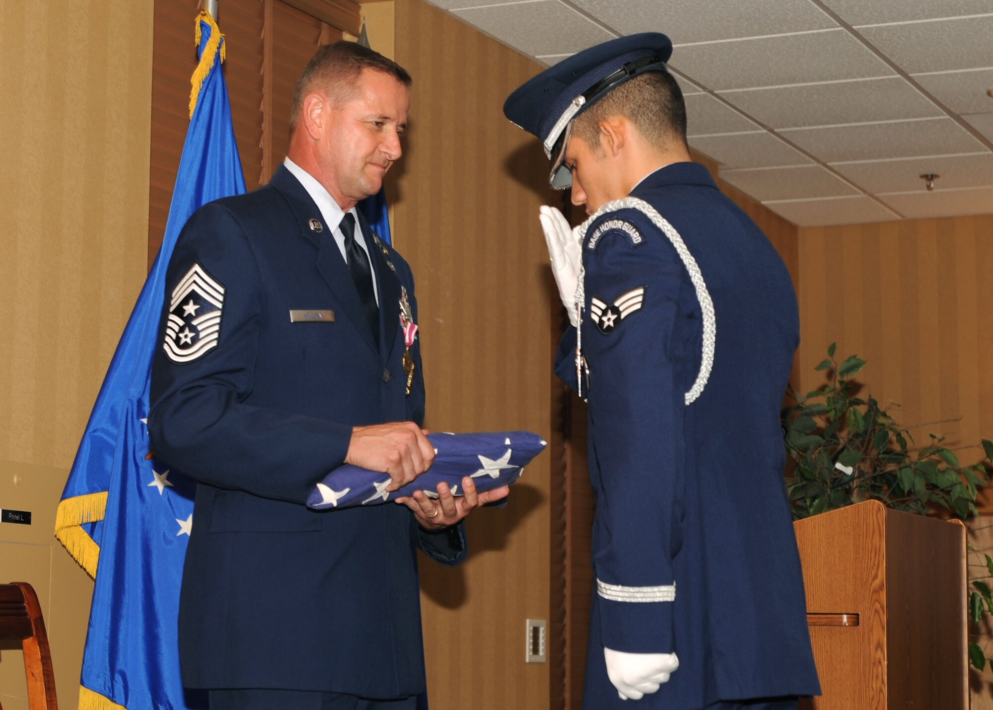DAVIS-MONTHAN AIR FORCE BASE, Ariz. -- Chief Master Sgt. Lloyd Hollen (left), 12th Air Force (Air Forces Southern) command chief, recieves the colors during his retirement ceremony here Aug 14.  Chief Hollen retired after nearly 29 years of active service.  (U.S. Air Force photo by Airman 1st Class Brittany Dowdle)