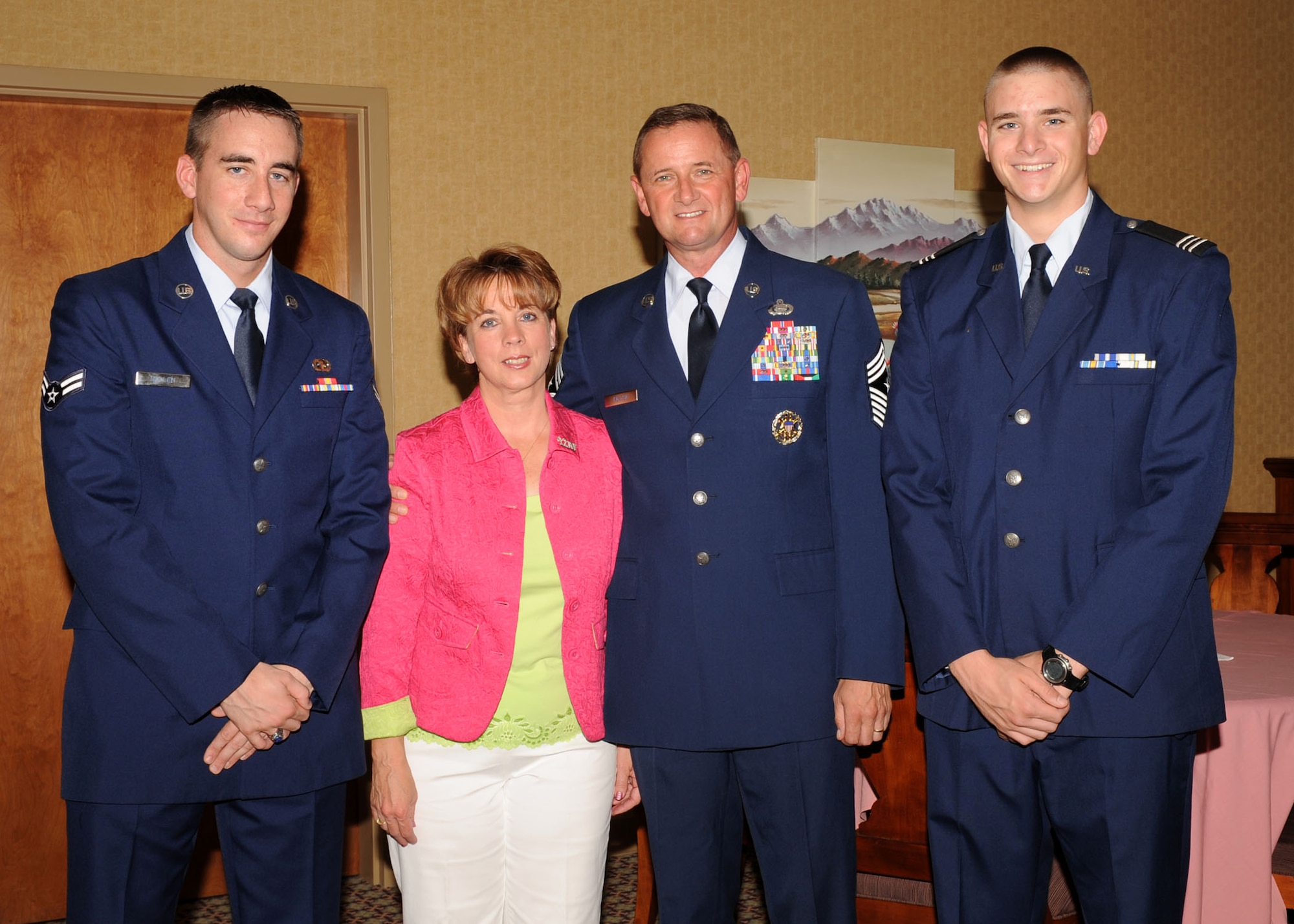 DAVIS-MONTHAN AIR FORCE BASE, Ariz. -- Chief Master Sgt. Lloyd Hollen (middle right), 12th Air Force (Air Forces Southern) command chief, stands with his wife Carol, and their two sons, Terry (left), an Airman 1st Class imagery analyst at Beale Air Force Base, Calif., and Greg (right), a Reserve Officer Training Corps Cadet Major at Florida State University.  Chief Hollen retired Aug. 14 after nearly 29 years of active service.  His sons emceed the retirement ceremony. (U.S. Air Force photo by Airman 1st Class Brittany Dowdle)